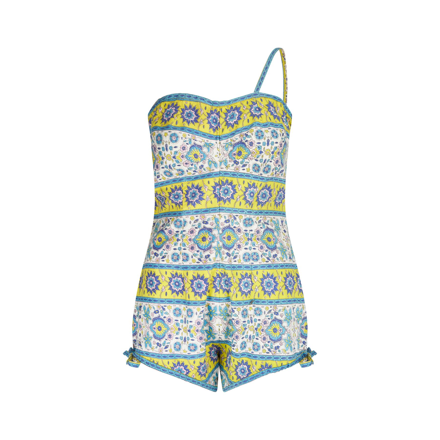 We really love the print on this original 1950s cotton swimsuit. It is a vibrant floral paisley design in yellow, pink, turquoise and lilac. The swimsuit has a singular strap and features a well executed design to the bust to enhance the female