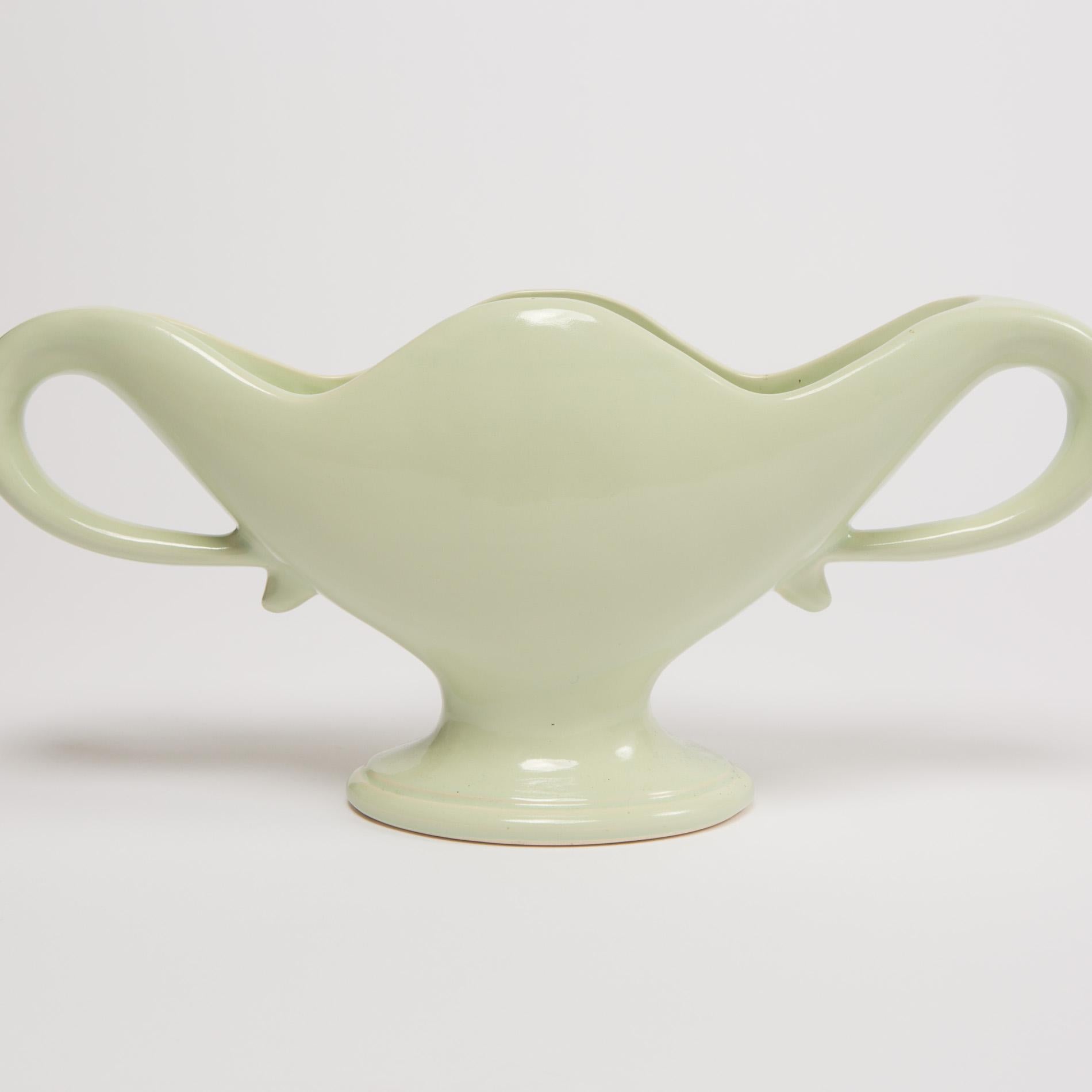 Perfectly proportioned pale green curved glazed vase designed by the famous English society florist Constance Spry, and made to her specification by Fulham Pottery located in Fulham, London.

Constance Spry was the go to florist for royal