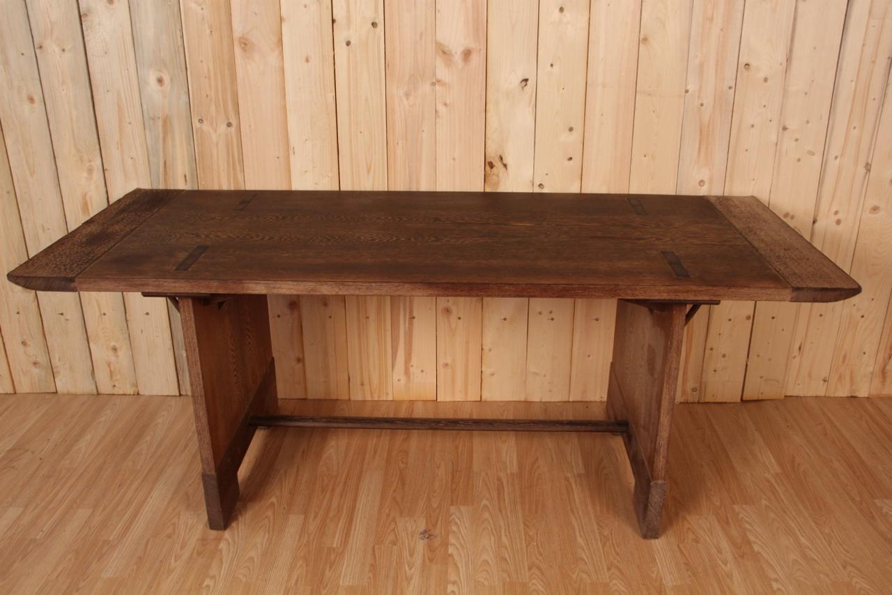 Large dining table from the 1950s in palm veneer, lateral base forming rectangular cutout tables, oval spacer, rectangular top finished at the ends with two elements forming a torii effect, worked with a gouge.
