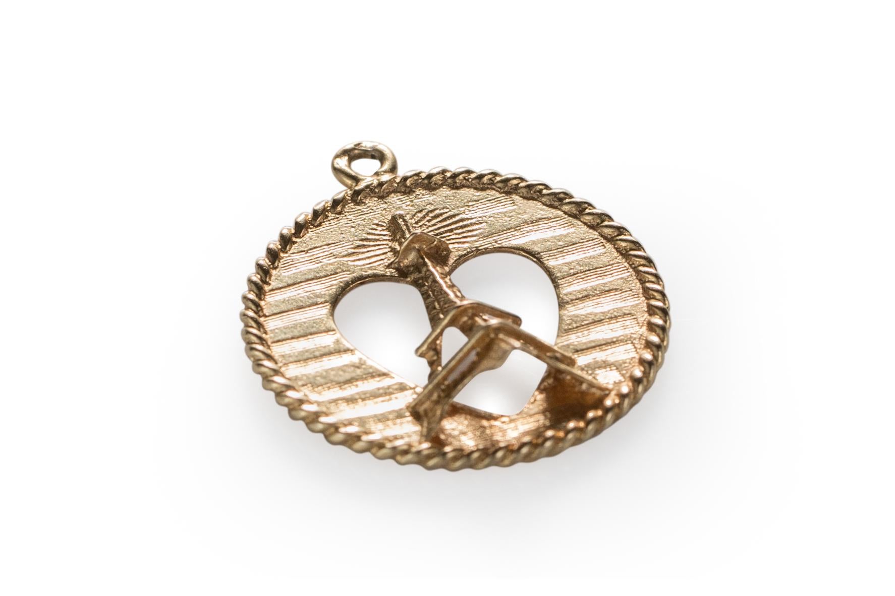 Adorable 14 karat yellow gold charm featuring ever so charming Eiffel Tower in a heart shape cut out on a solid gold panel background. 

The eiffel tower is a 3-d piece protruding out of the charm. There is a heart shape cut out directly behind it.