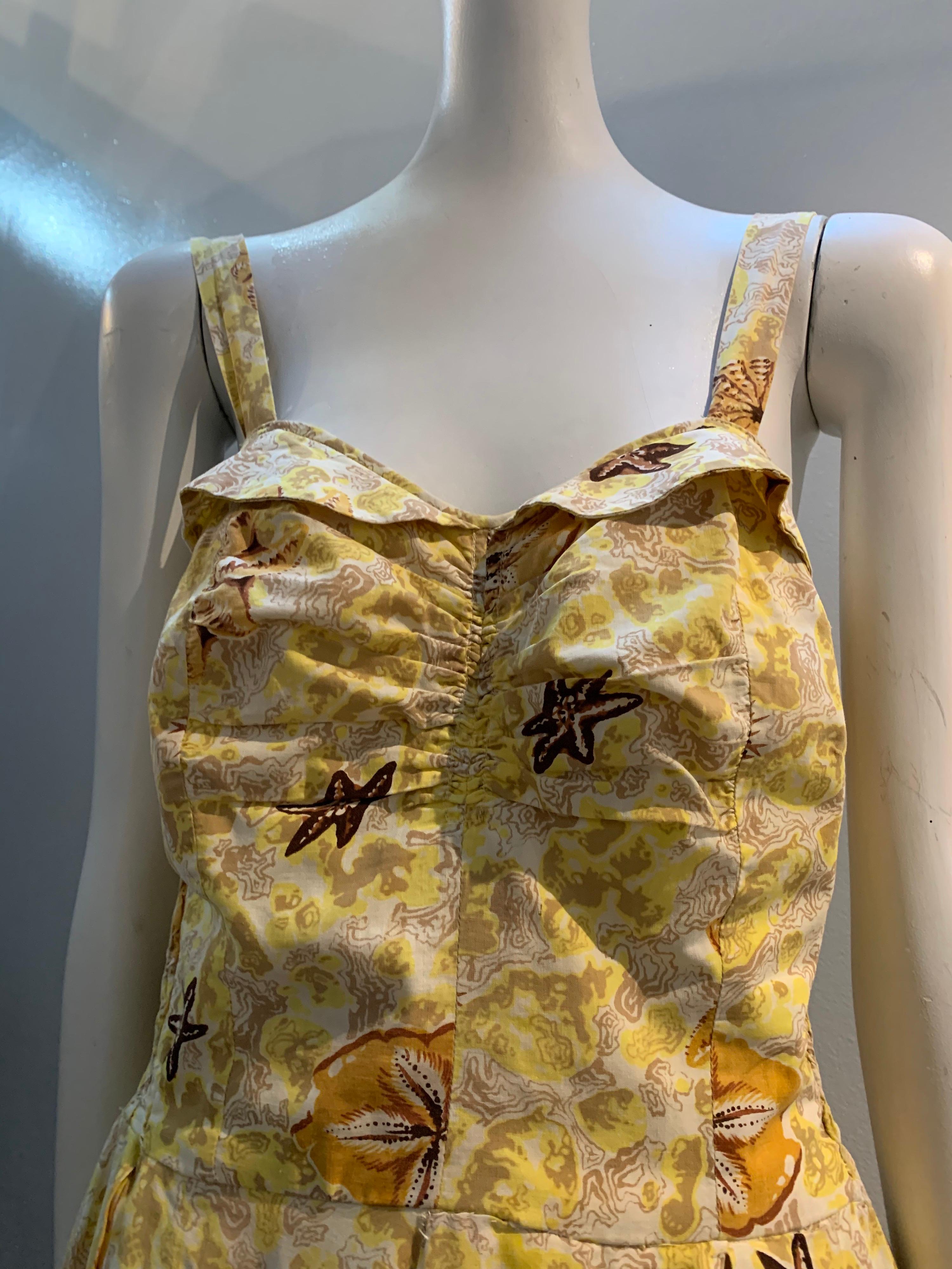 A sweet 1950s Pau Hana - Honolulu butter-yellow cotton sundress with stylized coral and sea shell print (including sea urchins, starfish and sand dollars). Ruched at center front and elasticized at side panels. Full skirt is deeply pleated. No