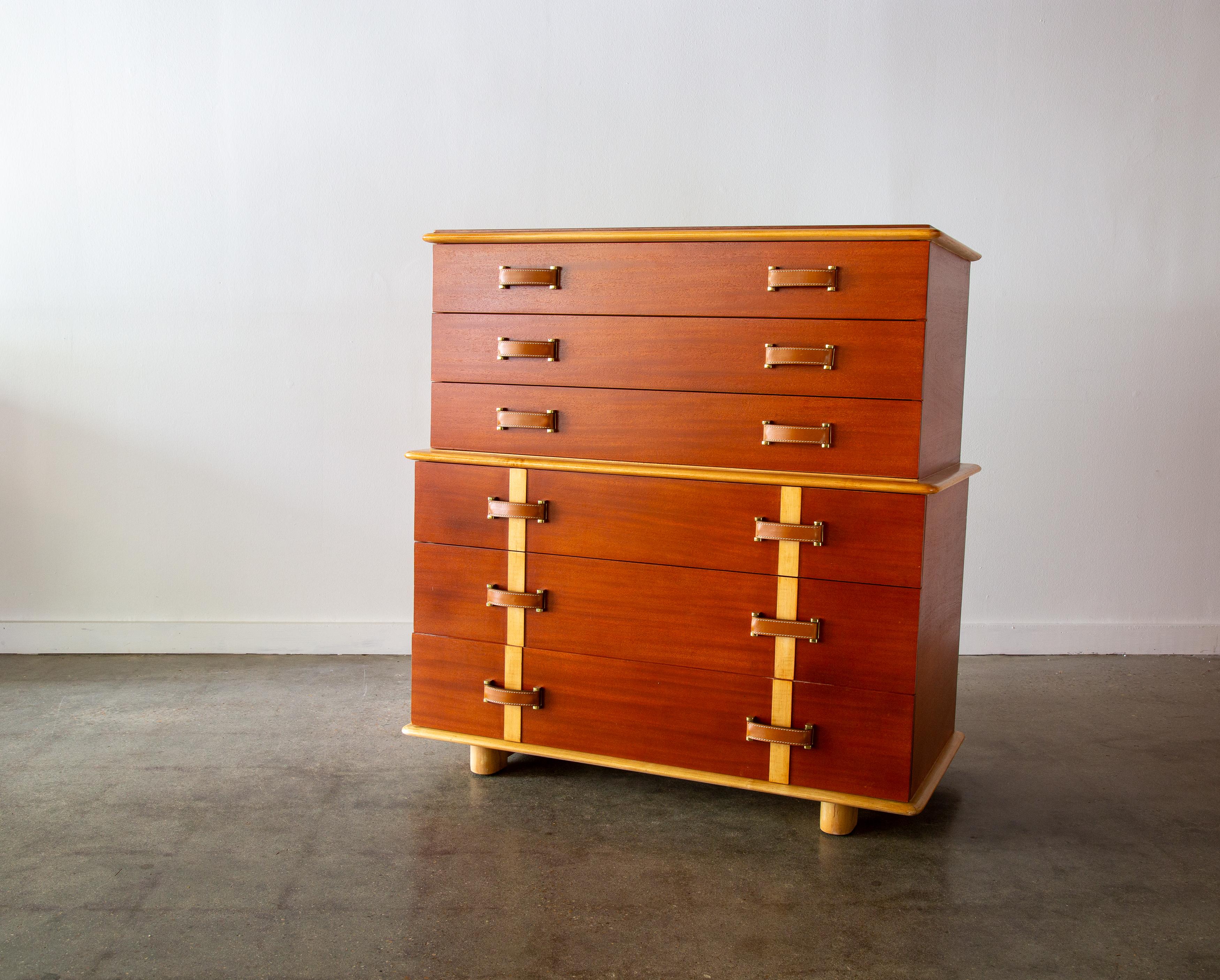 A 1940s Mid century Modern Paul Frankl Cabinet Chest of Drawers. A part of the station wagon series in contrasting Philippine  and Rock Mahogany and Maple featuring brass and leather handles. Interiors of the drawers in oak. Manufactured by the
