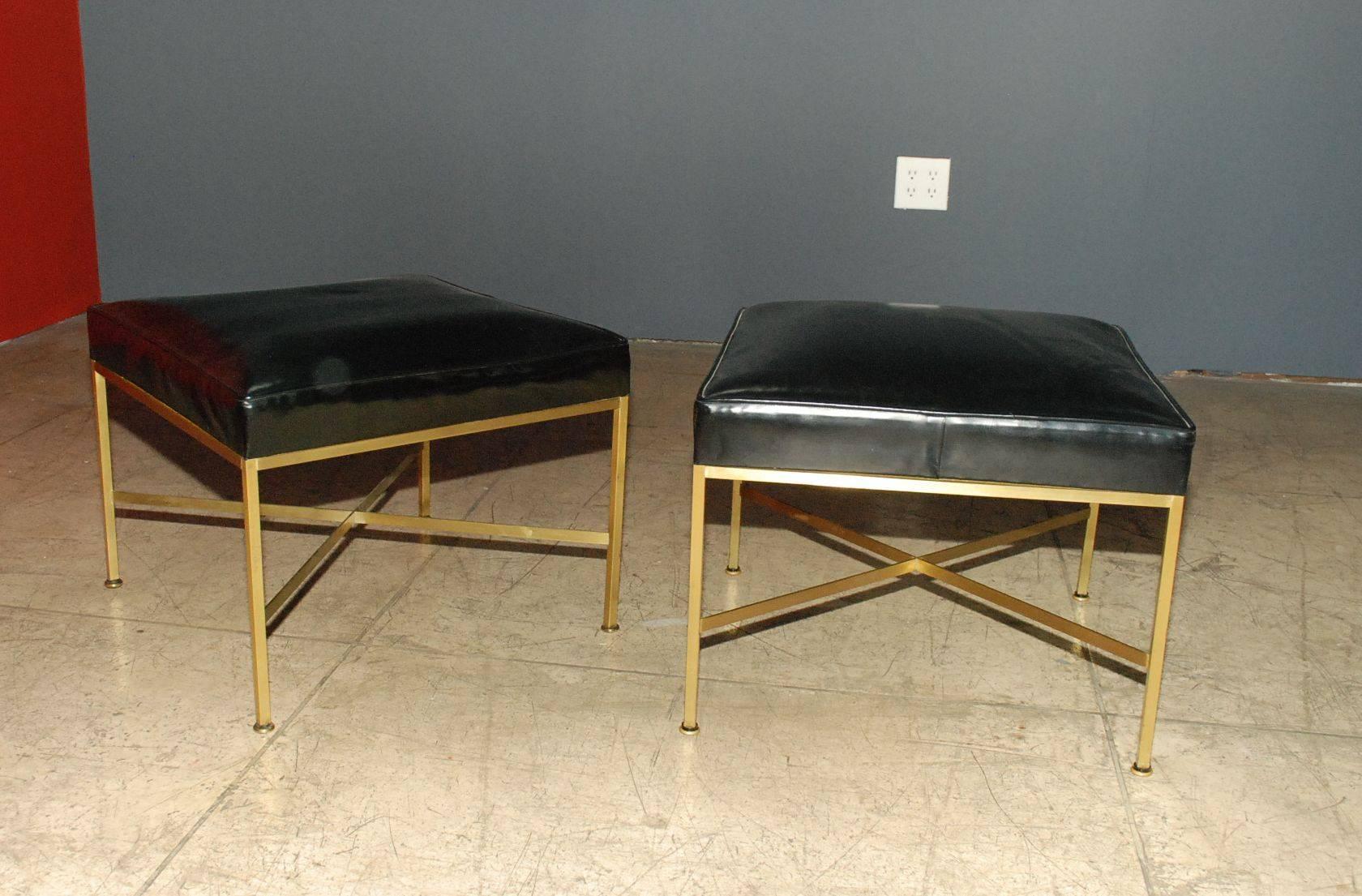 Pair of 1950s Paul McCobb X-base brass stools with original black vinyl upholstery.
