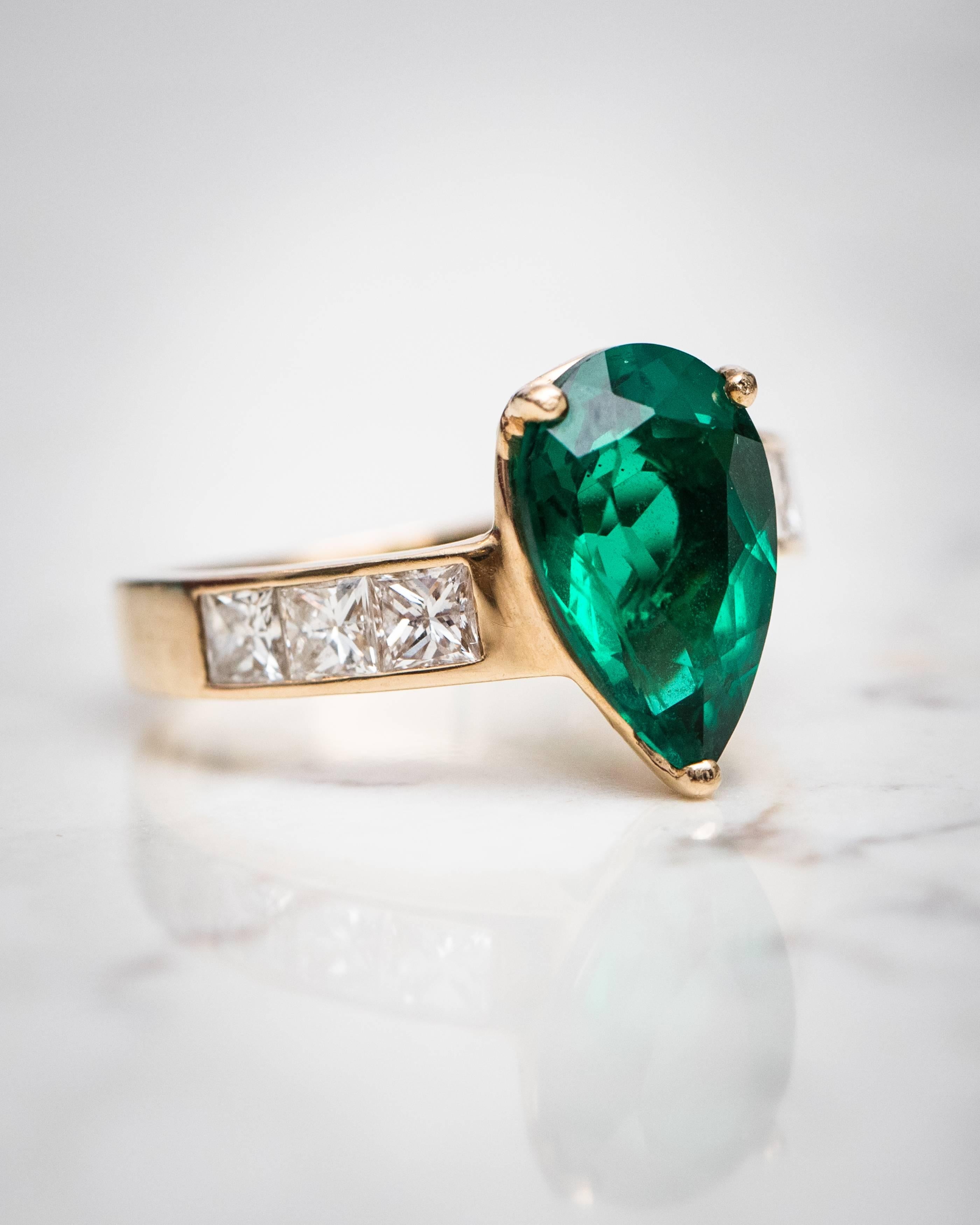 1950s Retro Princess cut Diamond, Pear cut Chatham Emerald and 14 Karat Yellow Gold Ring

Features 1.0 carat total weight Princess cut Diamonds, 3 carat Pear cut Chatham lab graded Emerald and 14 Karat Yellow Gold. The deep green emerald is securely