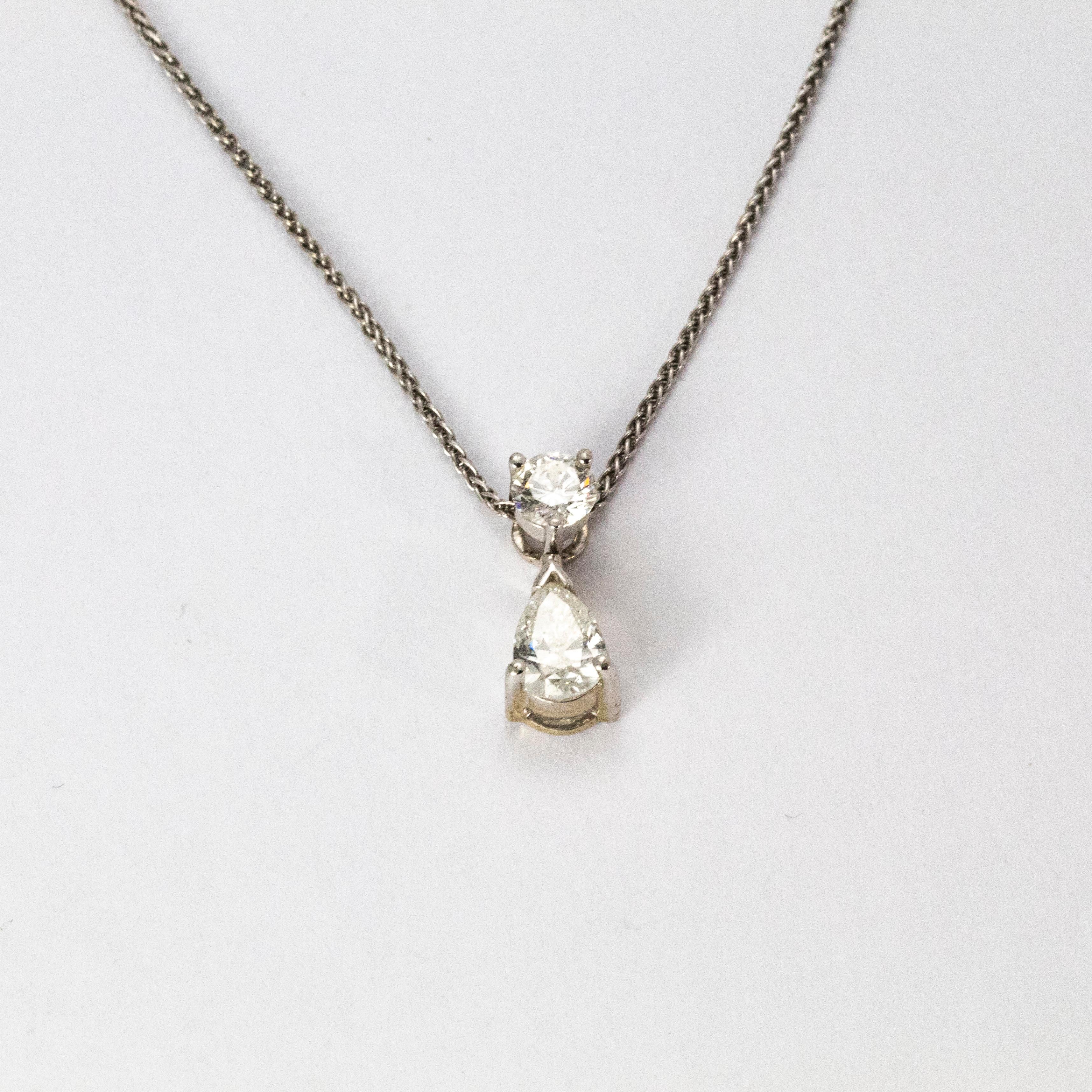 An elegant diamond and white gold necklace from the 1950s, beautifully designed with bright white stones. The first round brilliant cut diamond measures 35 points, hanging from it is an wonderful pear cut diamond measuring 50 points.

Chain length: