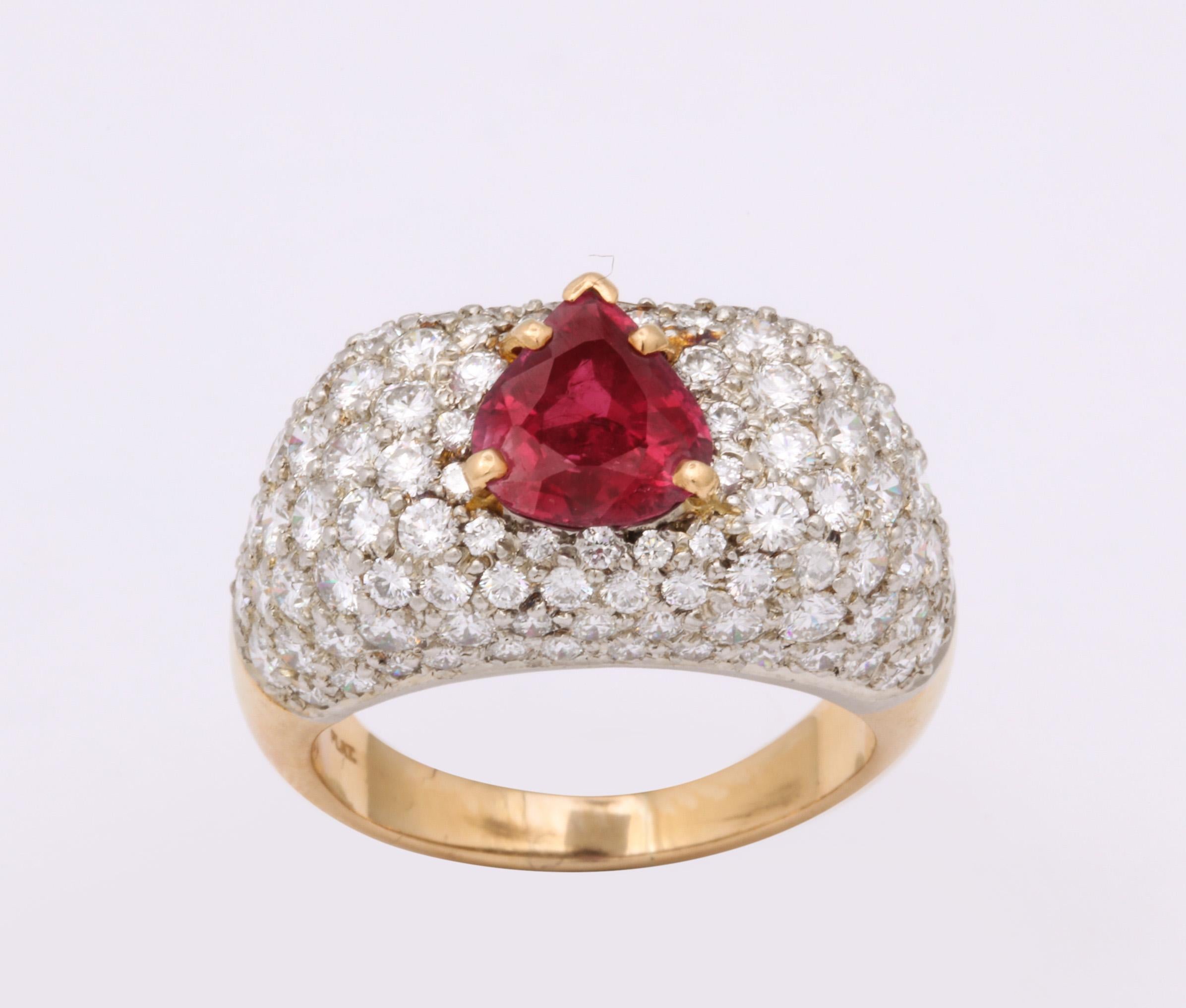One Ladies Dinner Ring Centering A 2.10 Carat Pear Shaped Faceted Prong Set Ruby. Cocktail Ring Is Further Embellished With Five Carats Of Full Cut Brillant Cut Diamonds. Ring Set In 14kt Yellow Gold And Diamonds Set In Platinum. Created In The