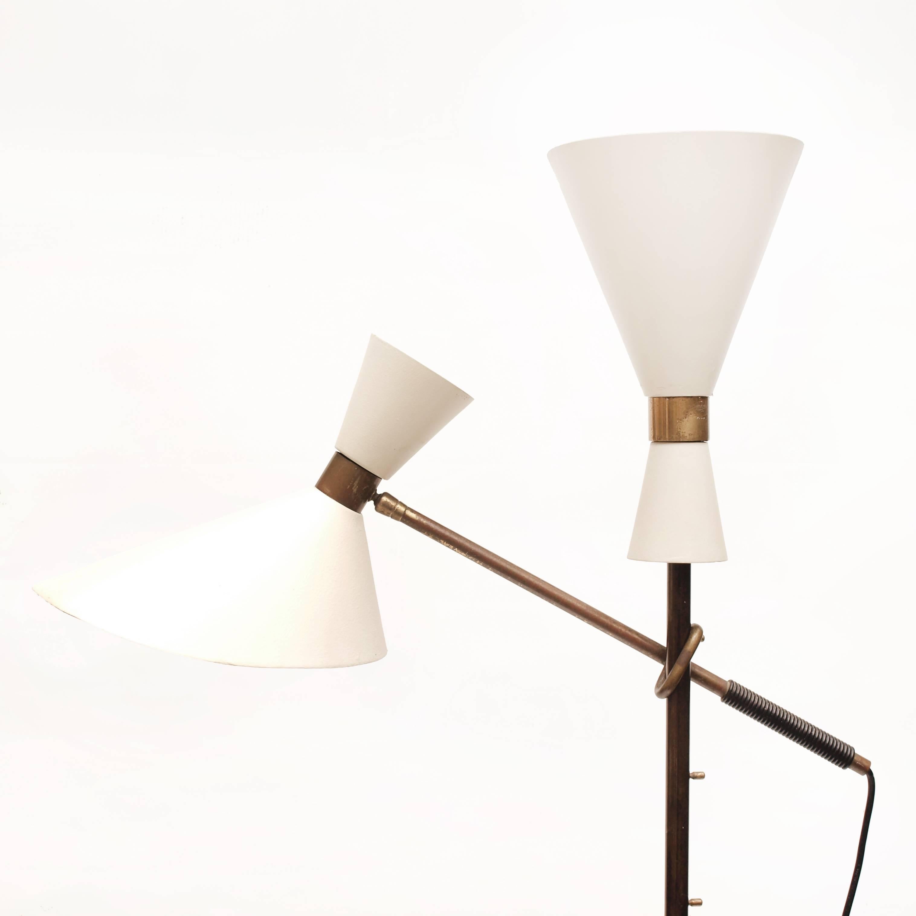 An iconic 'Pelikan' floor lamp by the Austrian designer Julius Theodor Kalmar and produced in Vienna, Austria. 
The architectural form is crafted of brass and lacquered metal with original off-white painted metal shades. The light has a unique