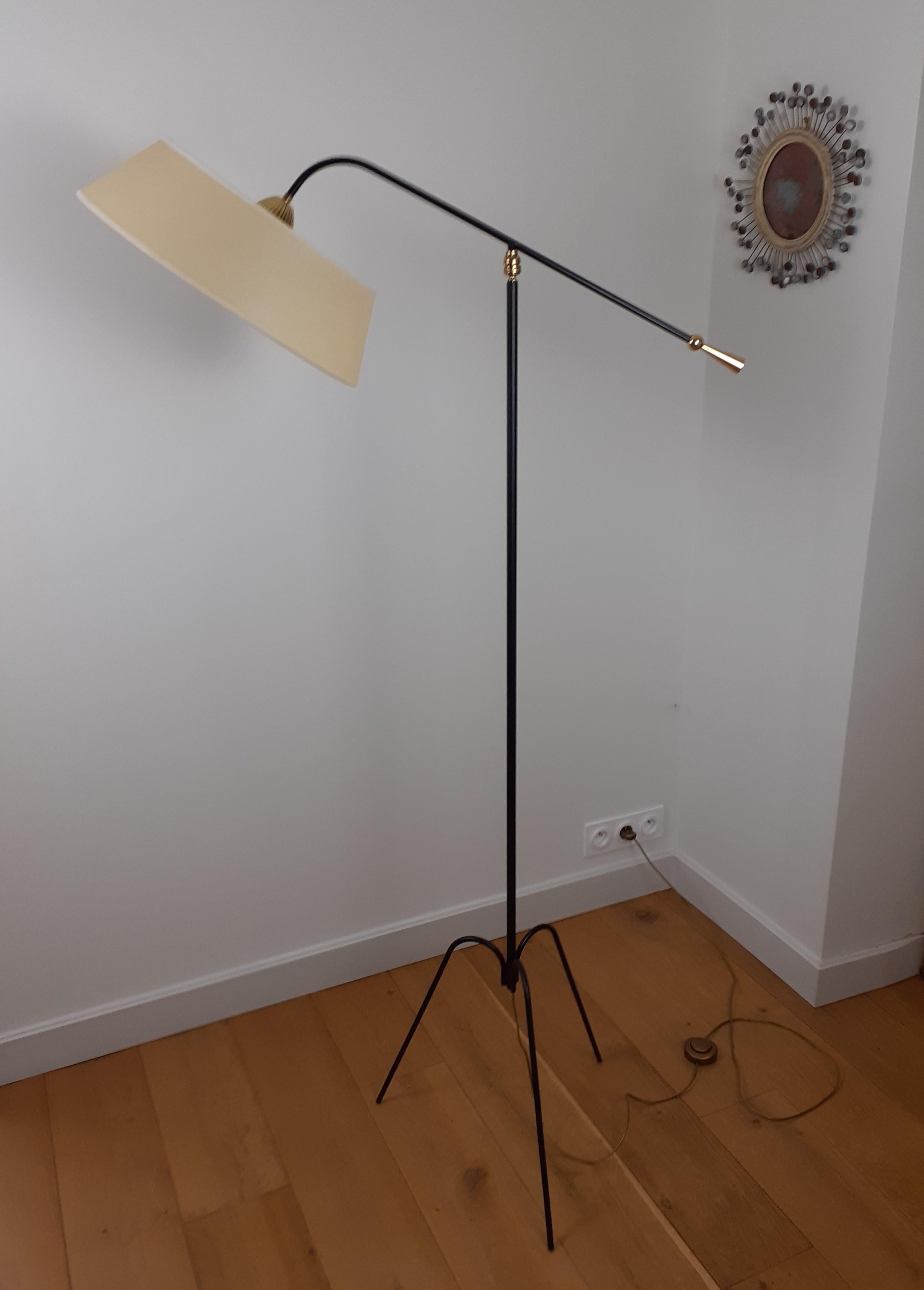 Floor lamp with pendulum and ball joint in black lacquered metal brass composed of a tripod foot in black lacquered metal.
A black lacquered metal arm fixed by a ball joint, supports a
a round and slightly conical shade.
At the other end of the