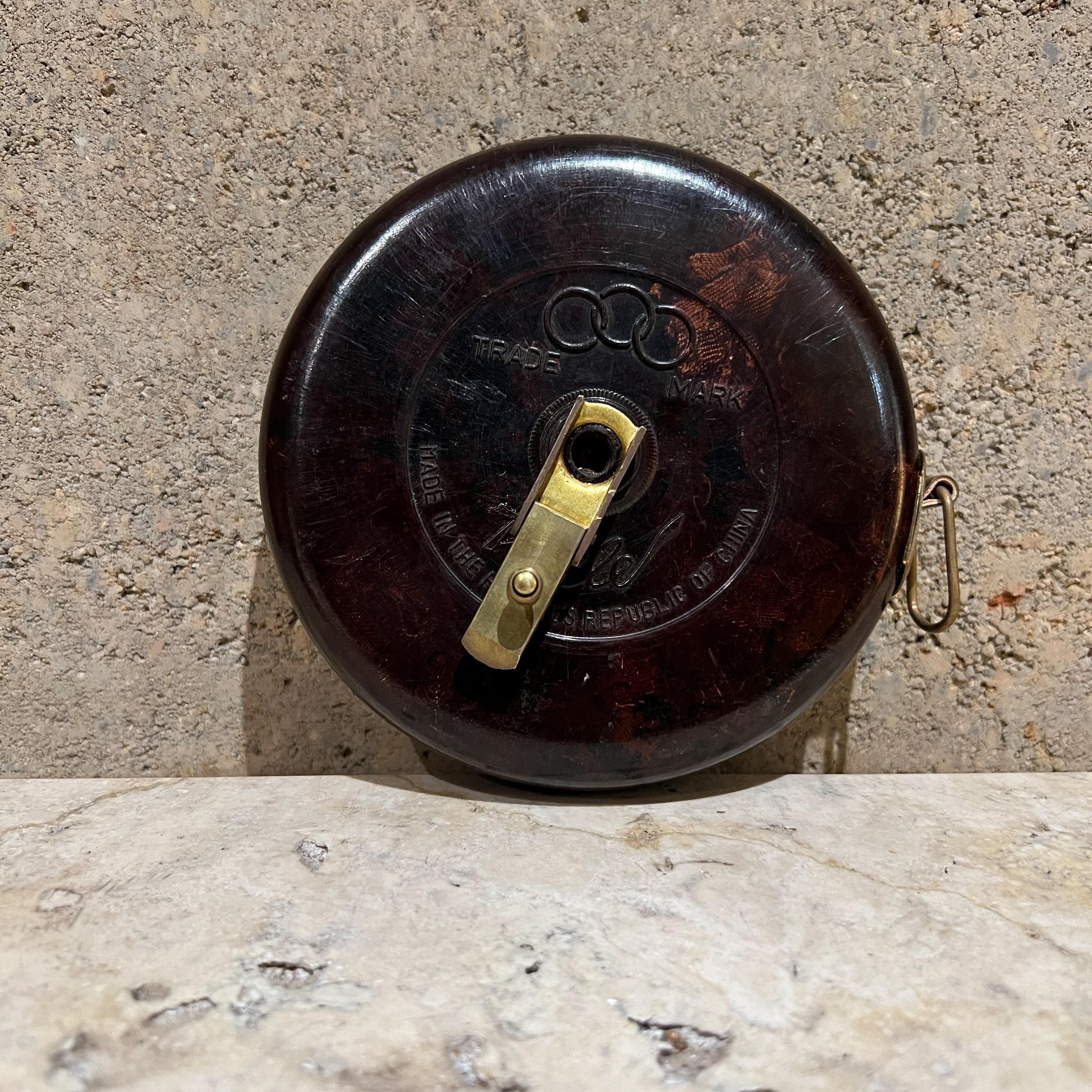 Vintage Tricle Bakelite Olympic Tape Measure 
made Peoples Republic of China
Cover made from dappled rich dark tricle bake-lite 
includes gilt brass fittings and cloth tape.
5.25 diameter x 2 thick
approx. 66 long 
Preowned original vintage