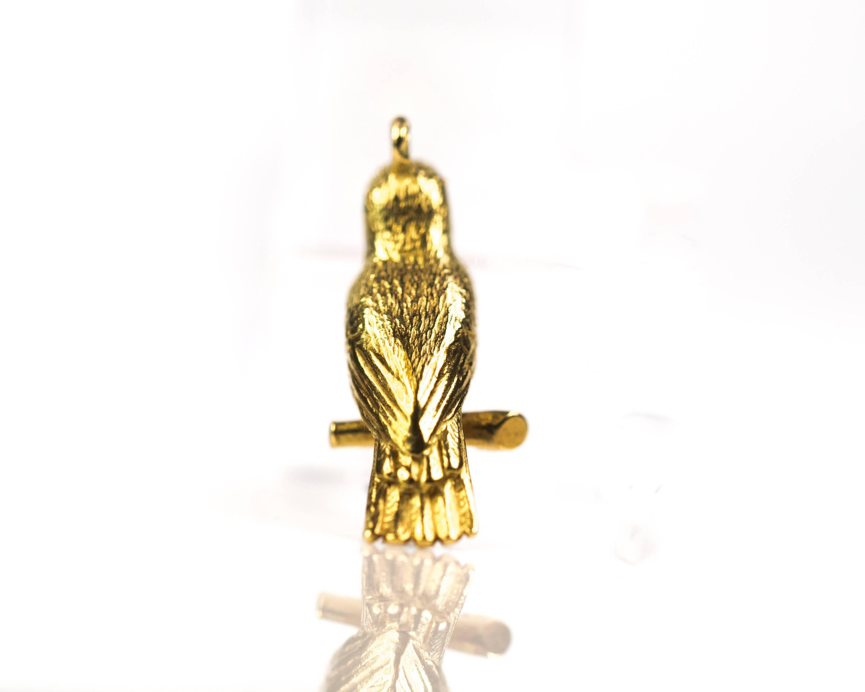 1950s Woodpecker Bird Charm - 18 Karat Yellow Gold

This richly detailed 18 Karat Yellow Gold Bird sitting on a Branch seems to be smiling! This charm is full of texture and details.
The head, back and underside of the bird are textured with short,
