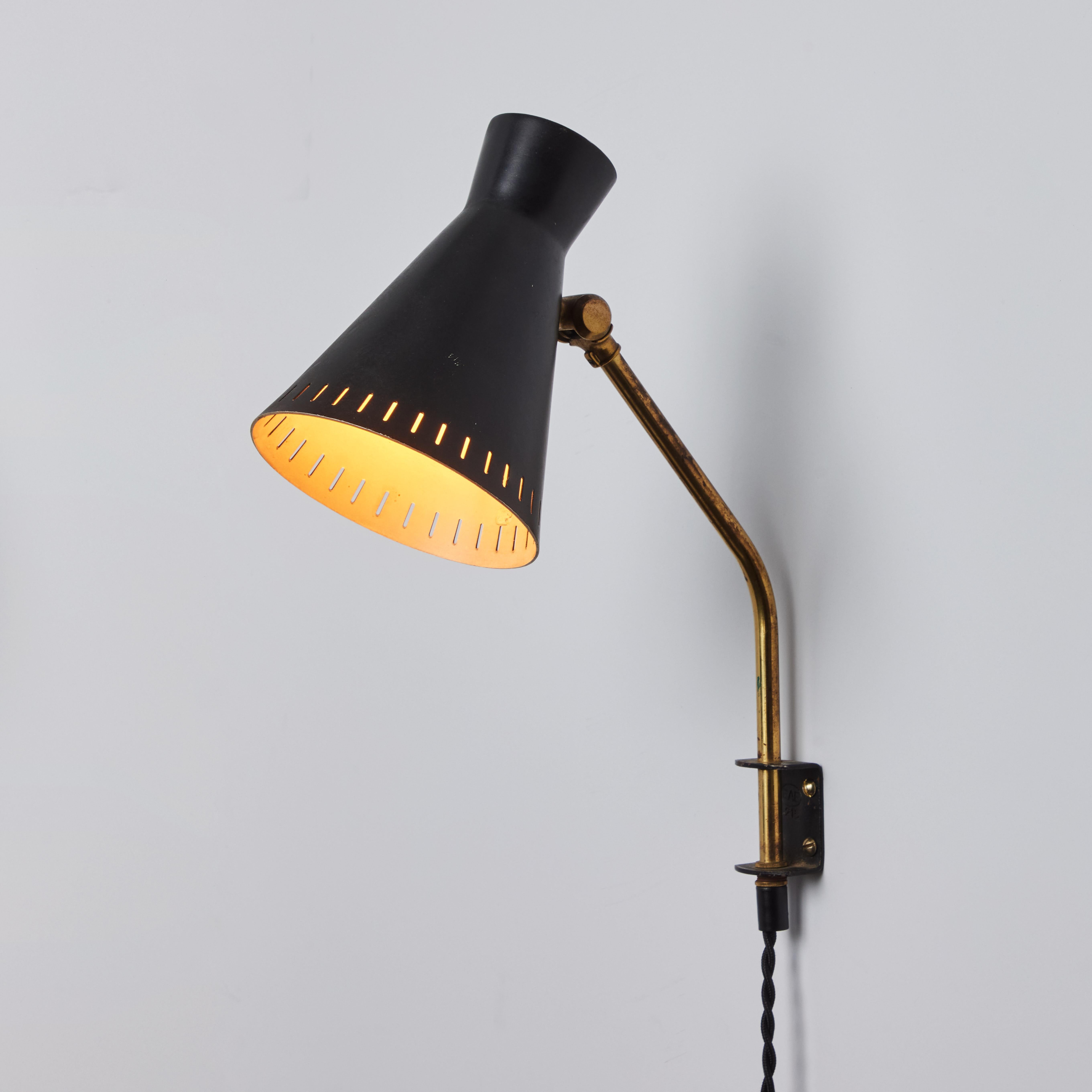 1950s Perforated Metal Diabolo Plug-In Wall Lamp Attributed to Mauri Almari. A rare and elegant design executed in sculptural black painted perforated metal with attractively patinated brass arm. Unmarked.

A contemporary of Paavo Tynell, the