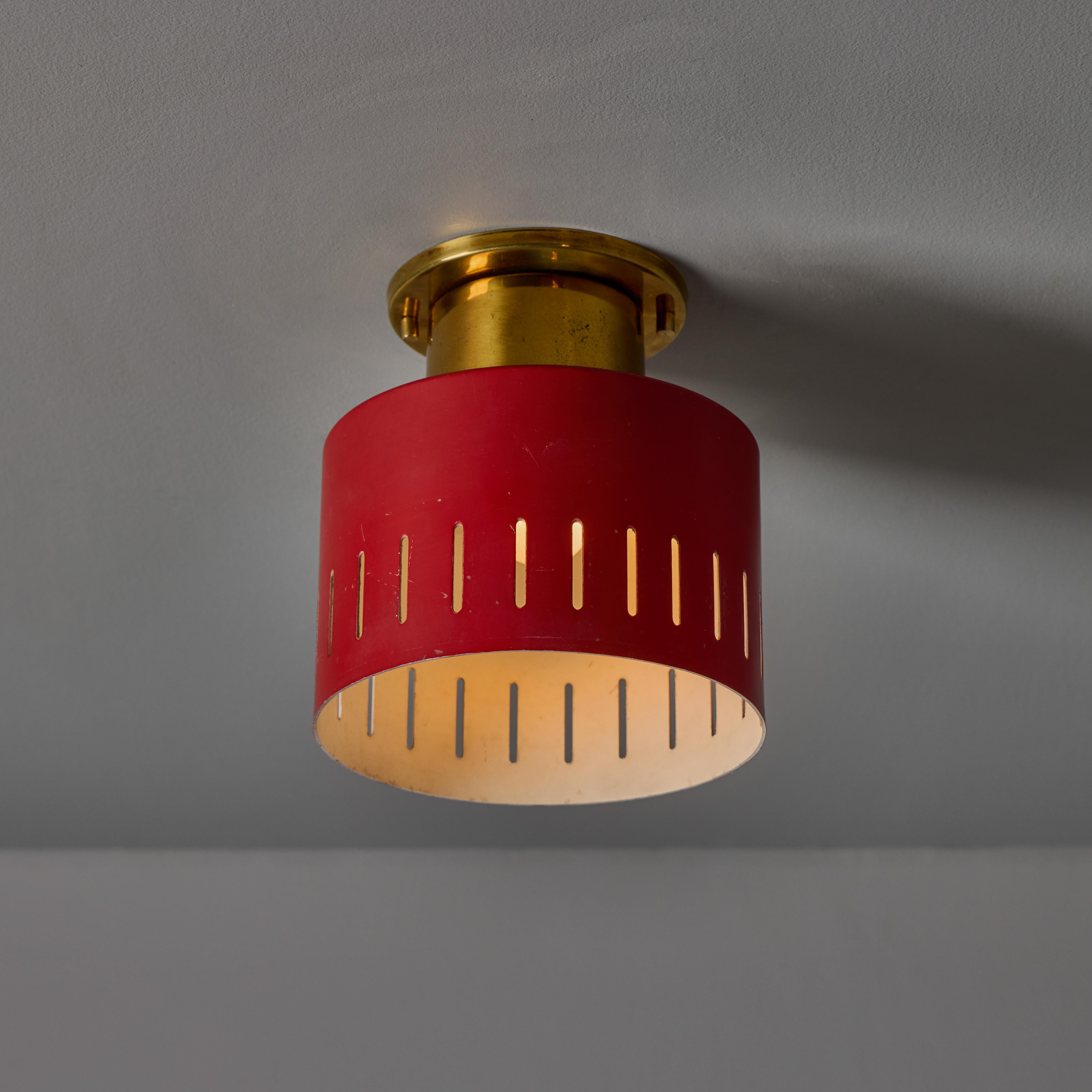 1950s Perforated Red and Brass Ceiling Lamp for Stilnovo. A quintessentially 1950s Italian design executed in perforated red painted metal with brass hardware. A highly functional and sculptural flush mount of attractive scale and incomparable
