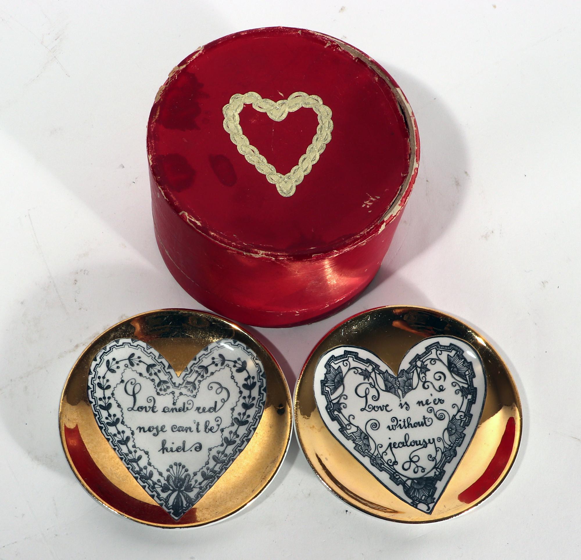 Piero Fornasetti love coasters & original red box,
1950's

Each coaster has a central white heart on a gold ground. Within each heart is a saying about love framed by a different heart-shaped border. They rest in their original early red