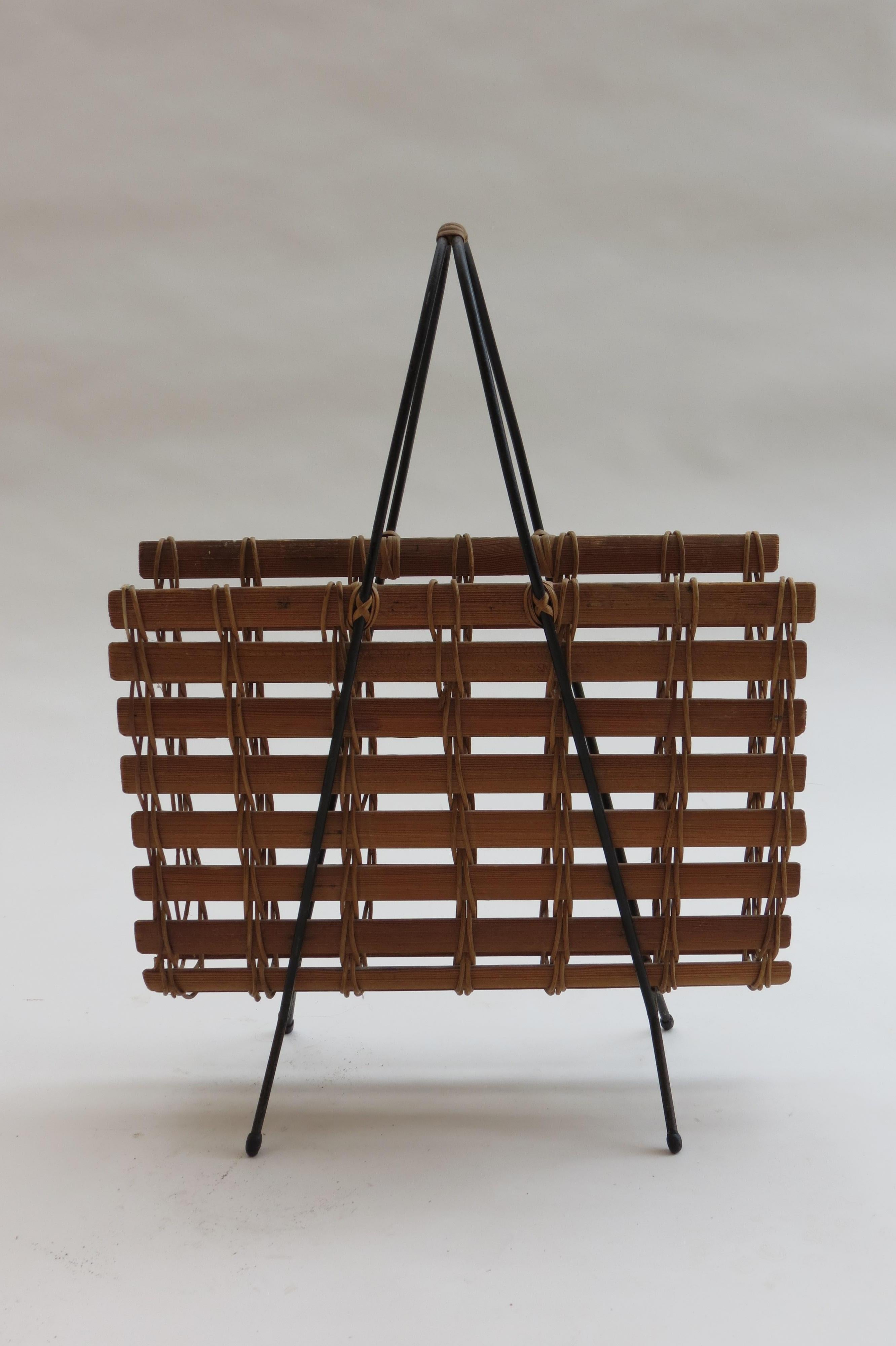 1950s stylish magazine rack made from pine shaped slats, held with rattan and a black painted steel frame with rubber feet.
Has a wrapped cane handle. Very stylish piece with Carl Auböck influence.
Could also be used in a bathroom for