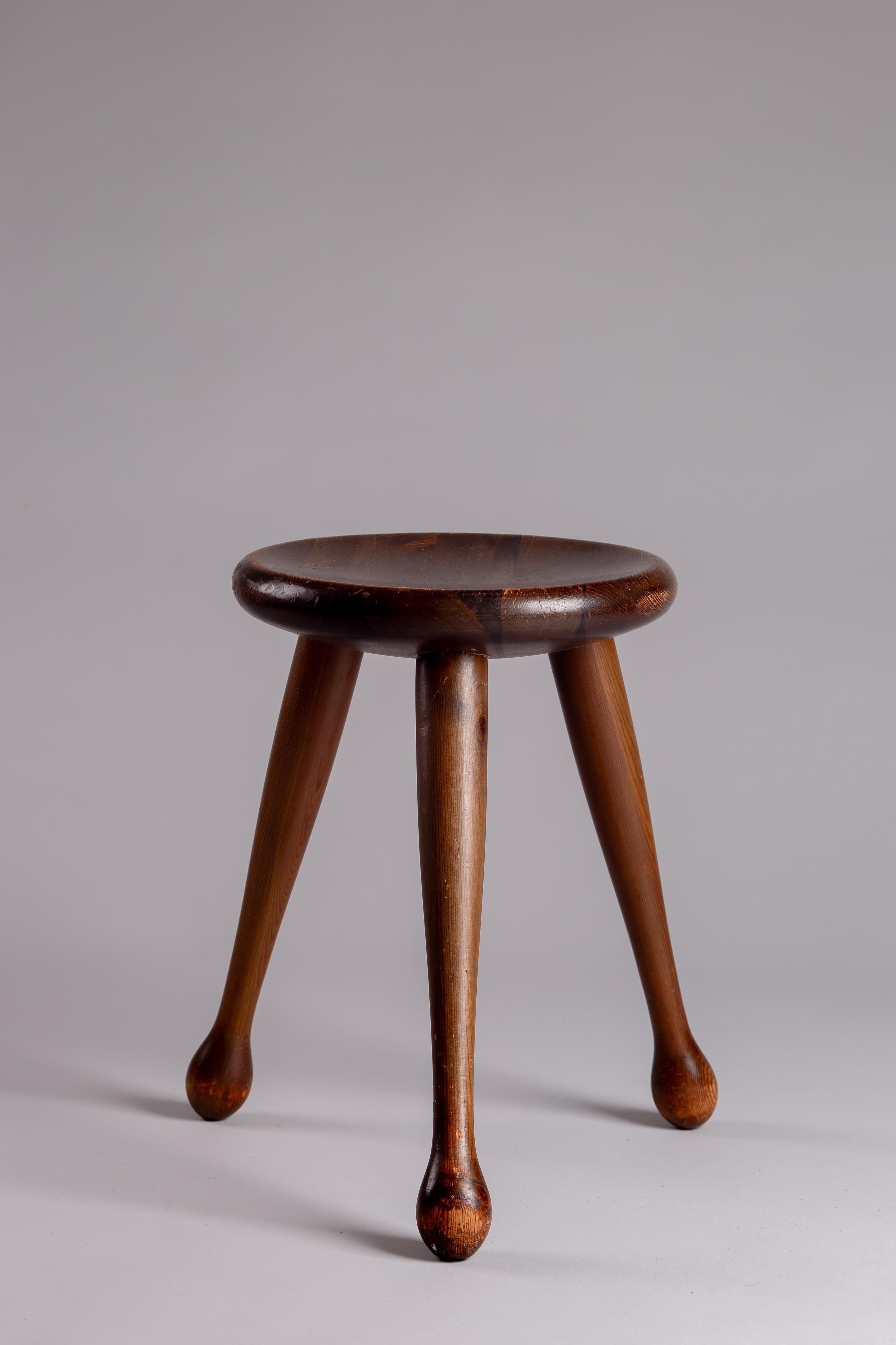 Transformez votre espace avec l'élégance charmante d'un tabouret en pin des années 1950 de Möbelkompaniet Ahl & Wallén, Suède. Ce tabouret sculptural en pin respire l'essence intemporelle du design scandinave du milieu du siècle, incarnant à la fois