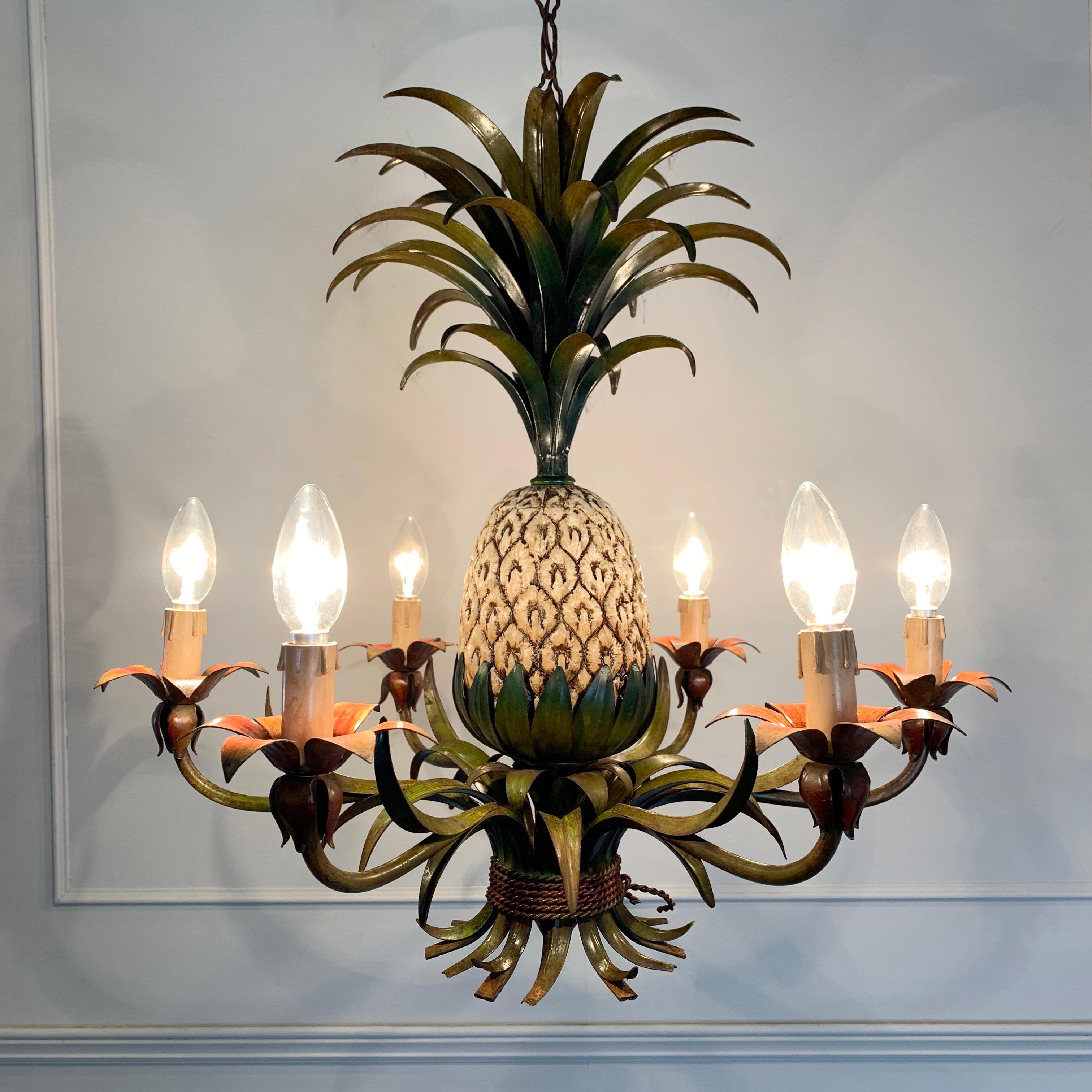 Stunning colored toleware pineapple chandelier
circa 1950s-1960s, Italy/France
The central pineapple is cream colored metal with dark highlights
The leaves and fronds are hand painted in mixed green tones with yellow/orange tones to