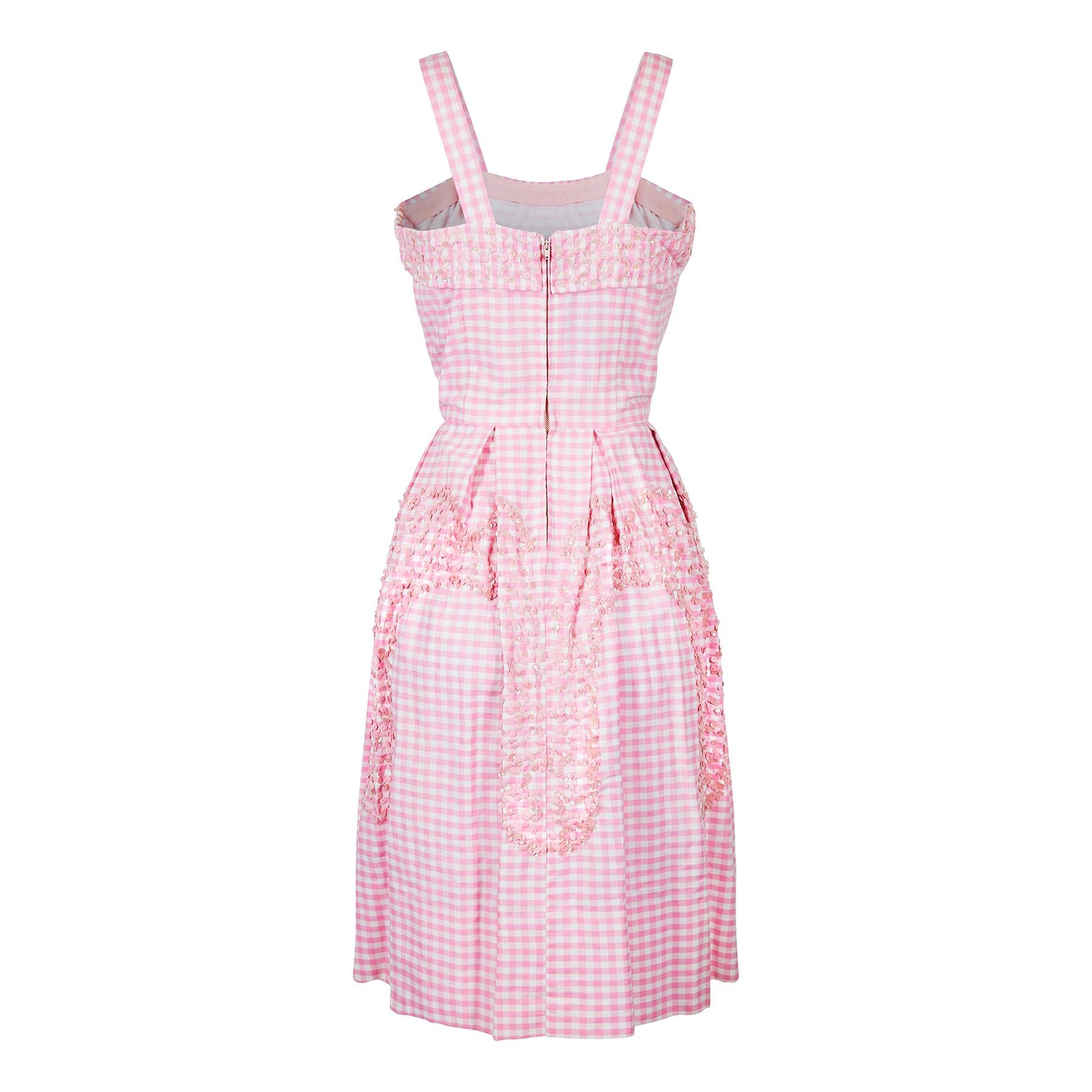 Éste es sencillamente uno de los mejores vestidos con estampado de cuadros que hemos visto. Es un ejemplo ultrafemenino y está bellamente confeccionado con un corpiño ajustado y con pinzas y una amplia falda con pliegues. El vestido está muy