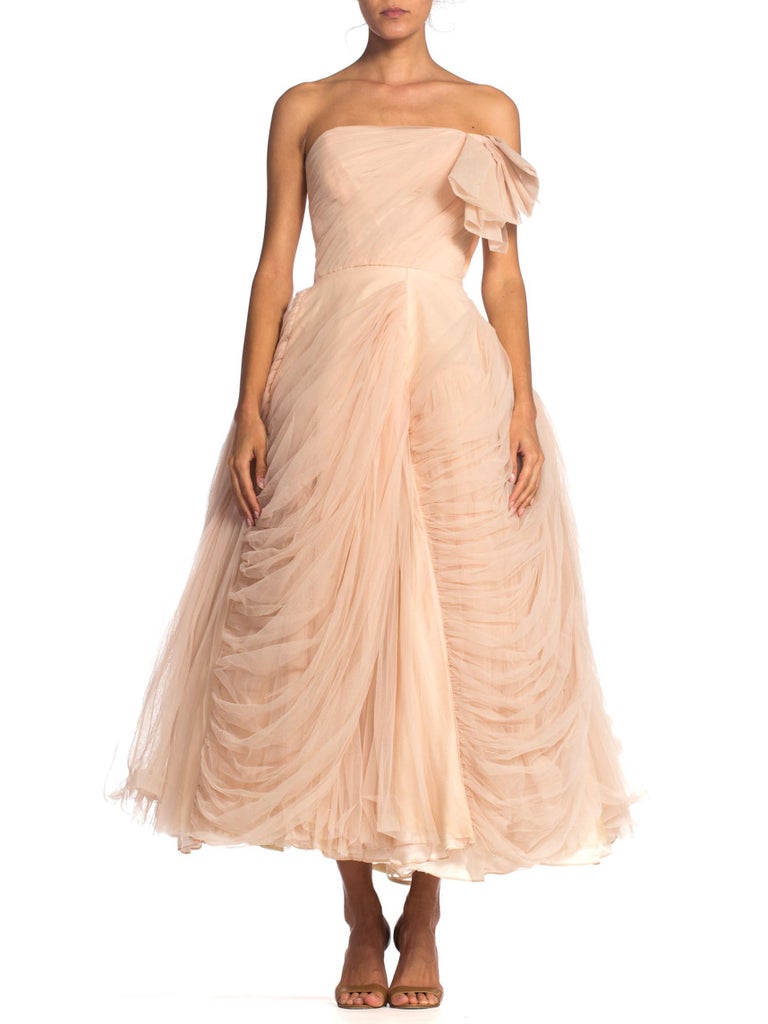 Dress comes with a separate petticoat so it can be worn less full. Very small waist.  1950S Blush Pink Rayon & Nylon Tulle Draped Strapless Gown In The Style Of Dior Jean Dessés 