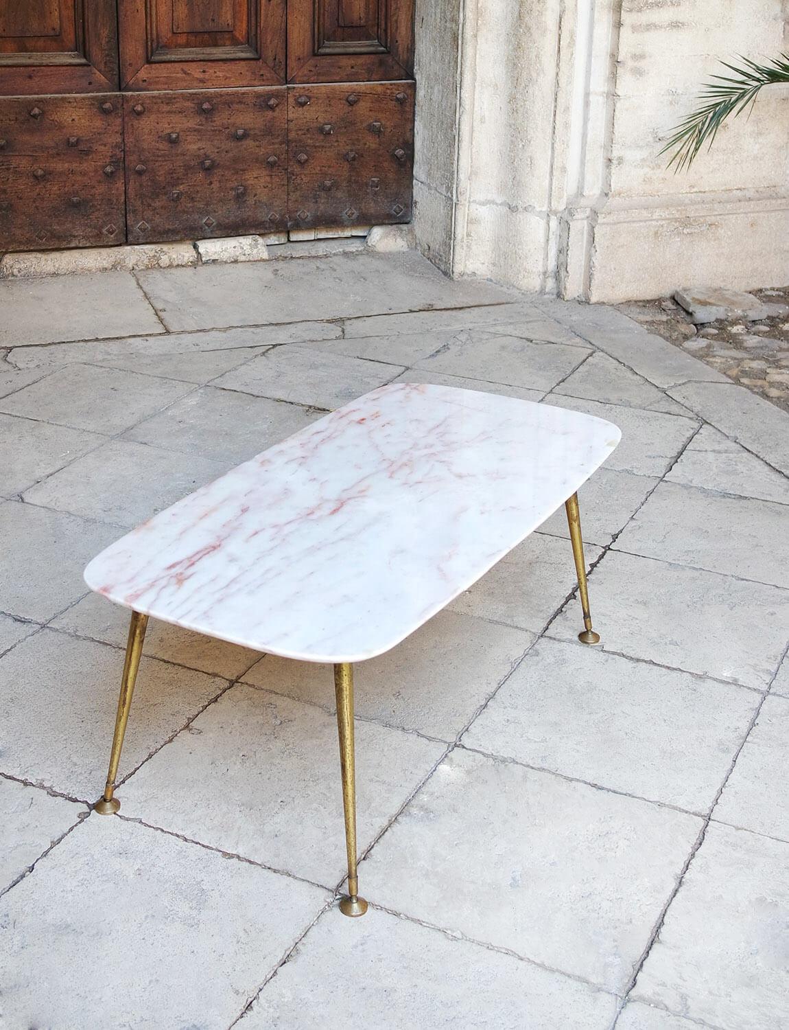 A small pink marble Italian side table with four brass legs and elegant moveable feet. The pink / peach marble has exceptional pink veins throughout. This piece is in good condition. There is one area of the marble where it has been filled (2cm x