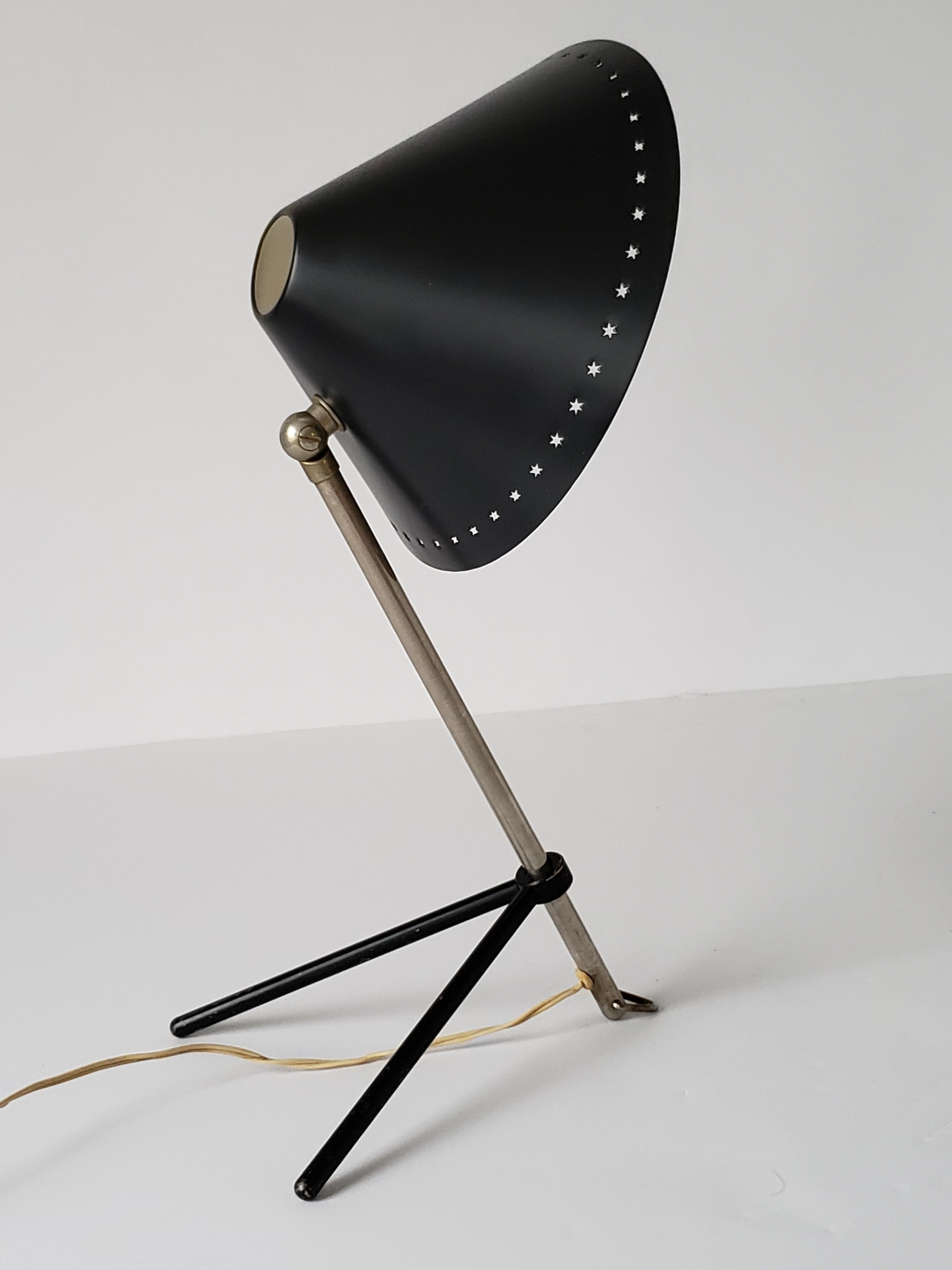 Versatile , agile , Classic midcentury European table or wall lamp. 

Enameled conical aluminium shade with pierced star motif. 

Aluminium stem rotate 360 degree and slide up and down on the solid steel enameled V base. 

Cast a large glowing