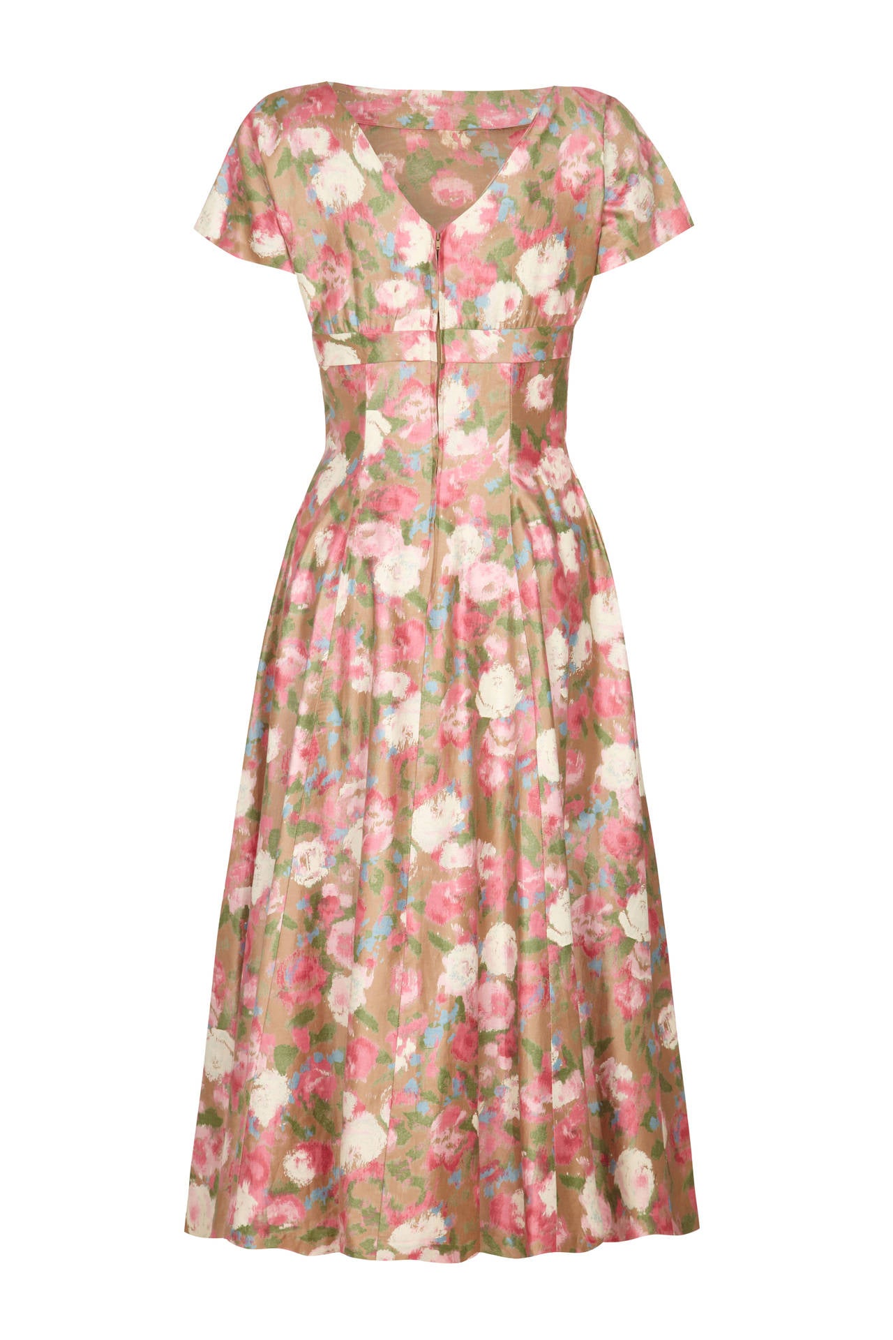 This exquisite feminine original 1950s polished cotton dress with pretty pale pink floral print features a classic full skirt and fitted waist with cap sleeves and a deep V to the back of the neckline.  Beautifully cut with a band under the bust it