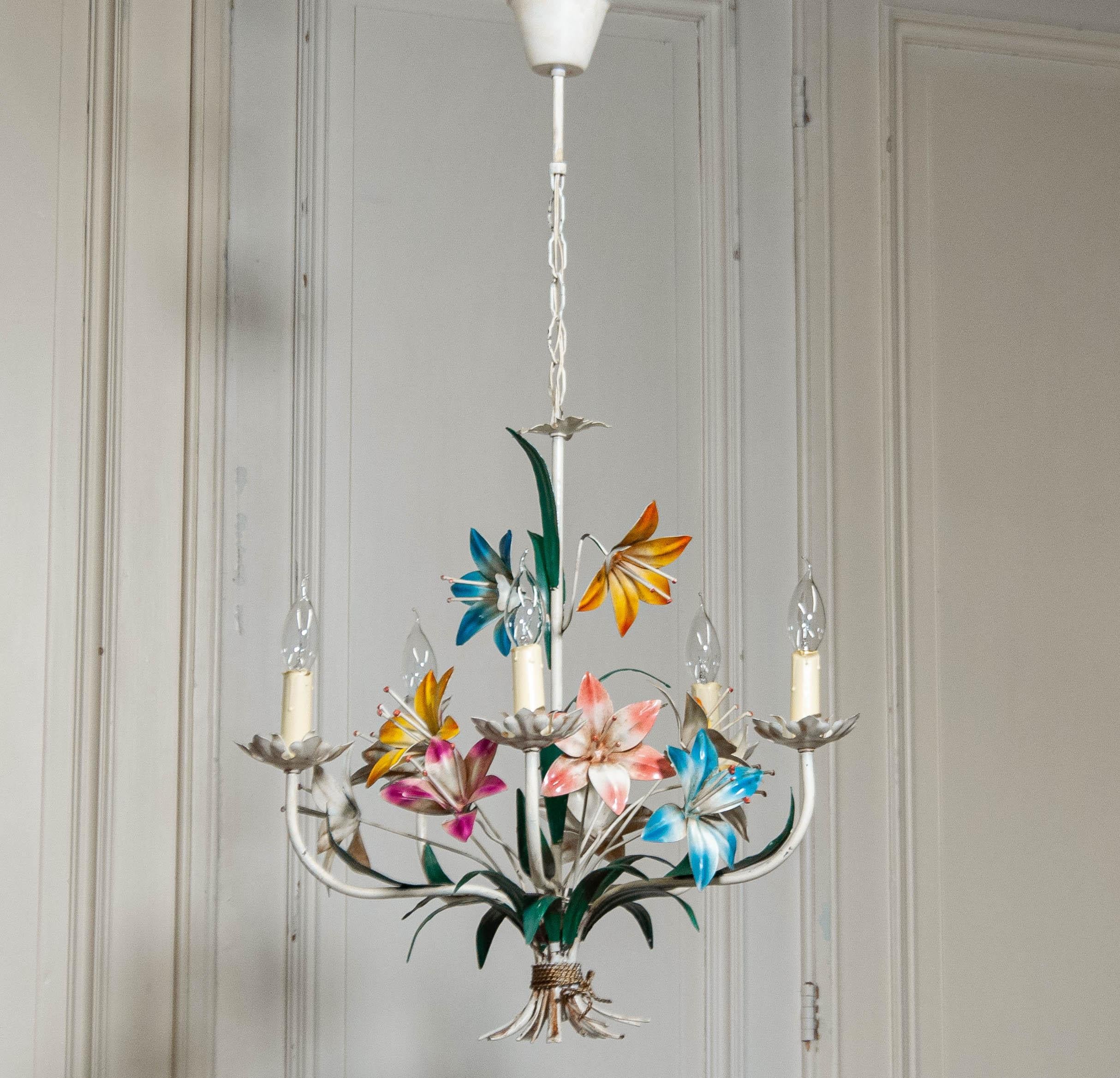This stunning Italian chandelier from the 1950s features an intricately designed metal frame with hand-painted polychrome flowers in vibrant hues. A true statement piece, it embodies the elegance and craftsmanship of mid-century Italian design.

The
