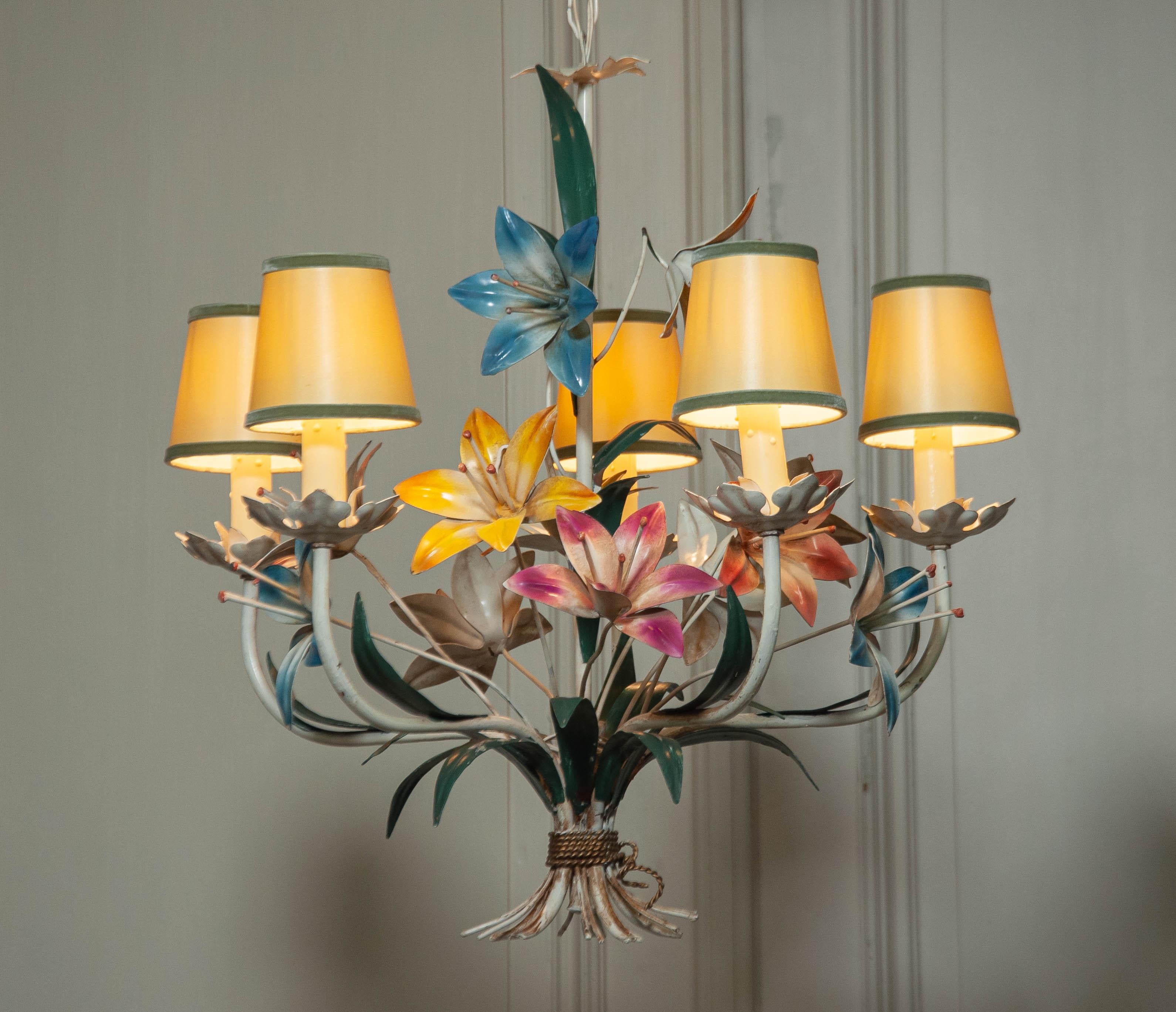 This stunning Italian chandelier from the 1950s features an intricately designed metal frame with hand-painted polychrome flowers in vibrant hues. A true statement piece, it embodies the elegance and craftsmanship of mid-century Italian design.

The