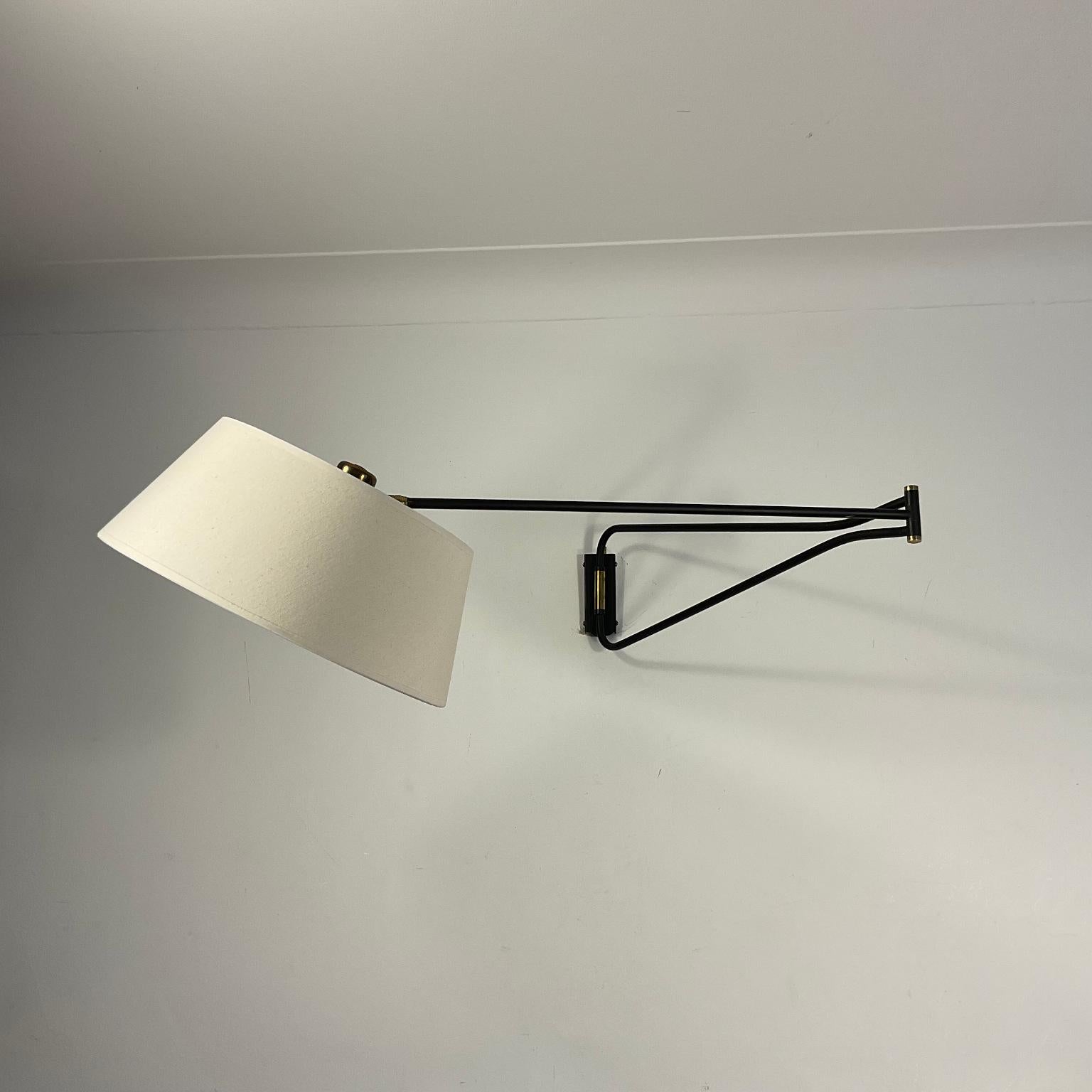 1960s Articulated Potence wall light by René Mathieu for Maison Lunel with brass finish and hand switch. 
Closed arm dimension 70cm
Extended arm dimension 126cm
Linen lampshade included 