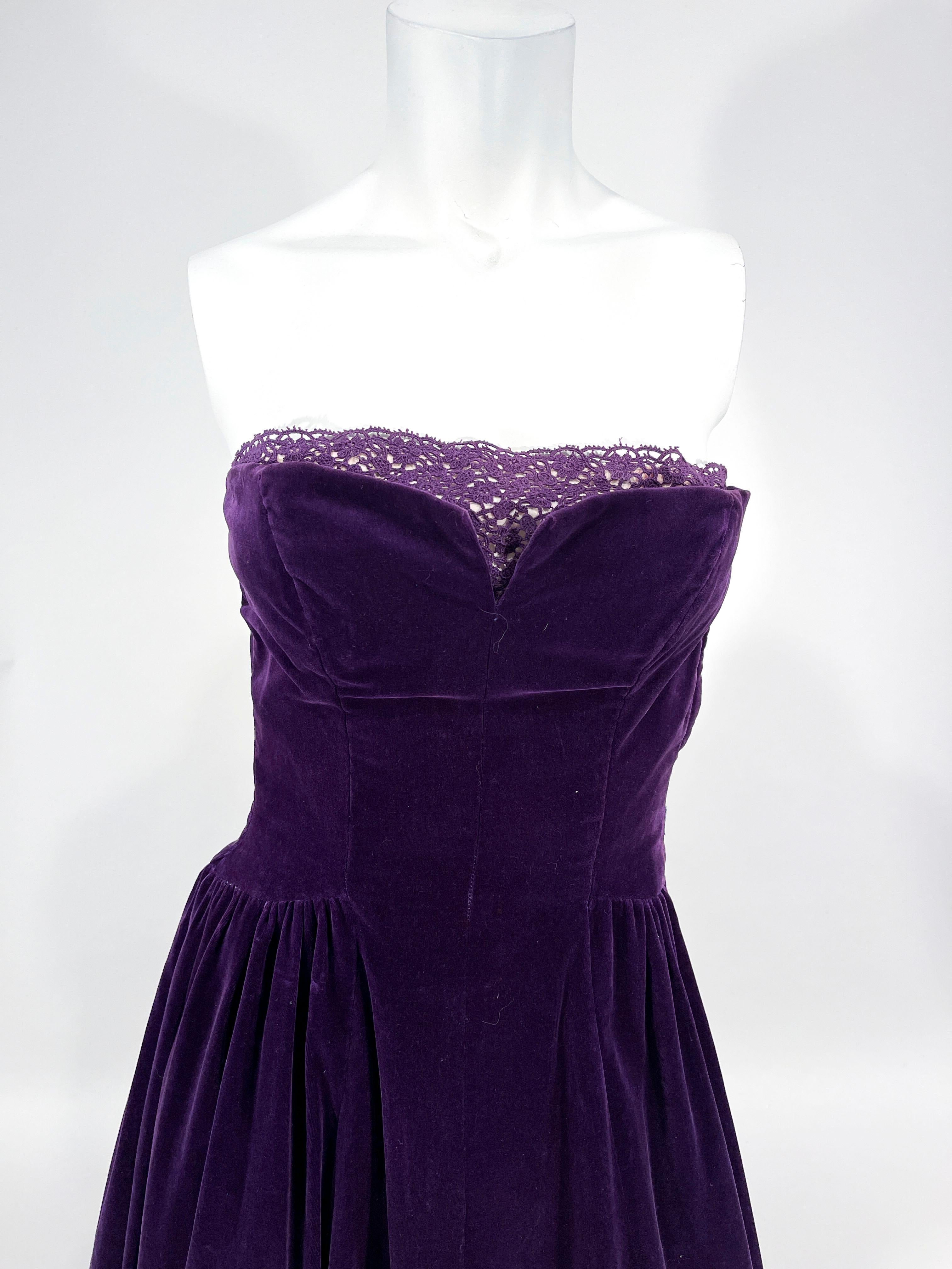 1950s Deep purple velvet strapless party dress. The top of the bodice is adorned with illusion purple lace modestly panel to complement the sharp v-neckline. The full skirt is ankle length and interior of the bodice is boned to provide shape.

This