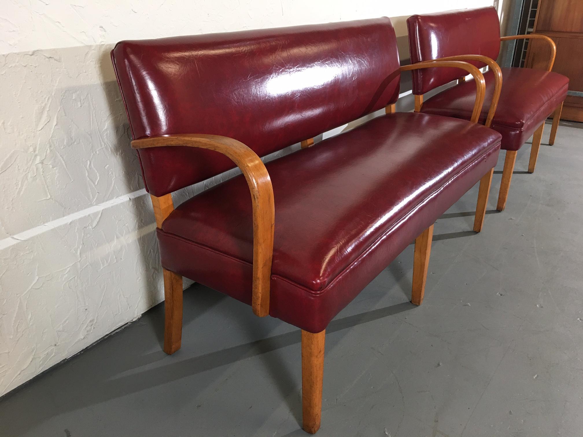 Pair of mid-century railroad bench. The arms are curved wood with six tapered straight legs. Covered in vinyl.