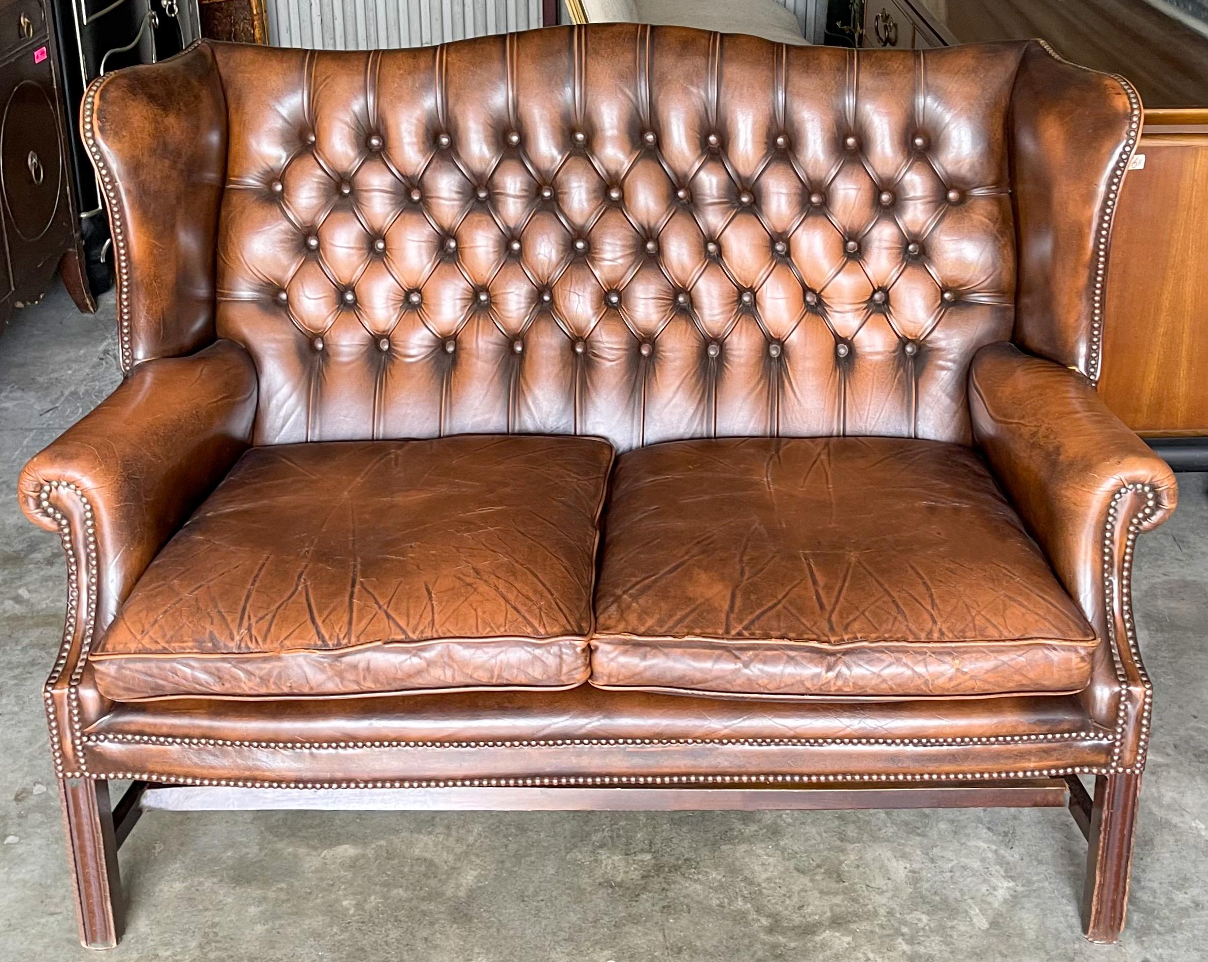 I love this handsome piece! This is a 1950s English tufted leather Chesterfield settee or sofa. The saddle leather has a wonderful patina. The wood is mahogany. It is unmarked. I will add additional photos shortly.

My shipping is for the