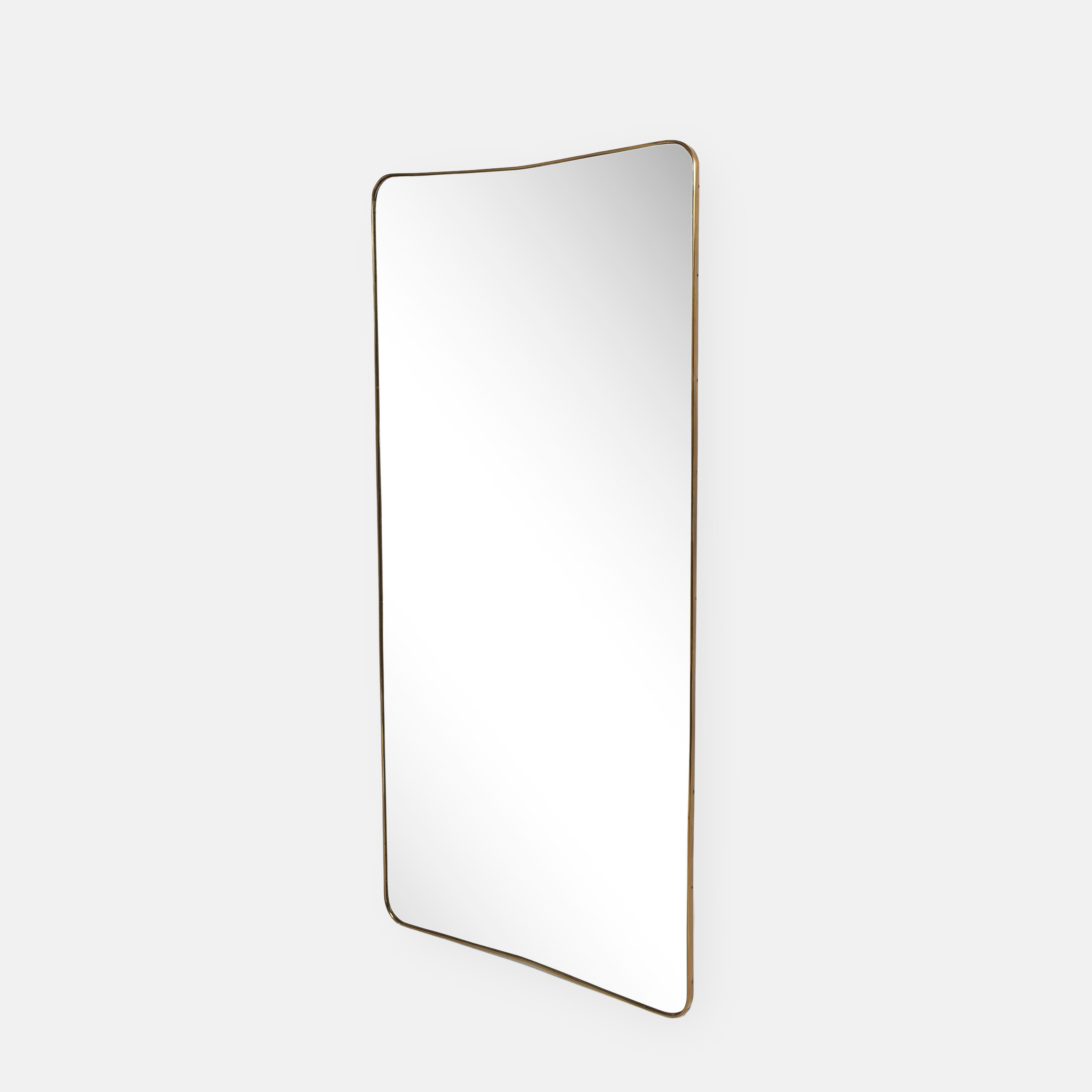 1950s rare original Fontana Arte modernist grand scale wall mirror consisting of shaped brass frame with gently arched and rounded top which slightly tapers towards the bottom and original mirrored crystal glass This chic and rare mirror is