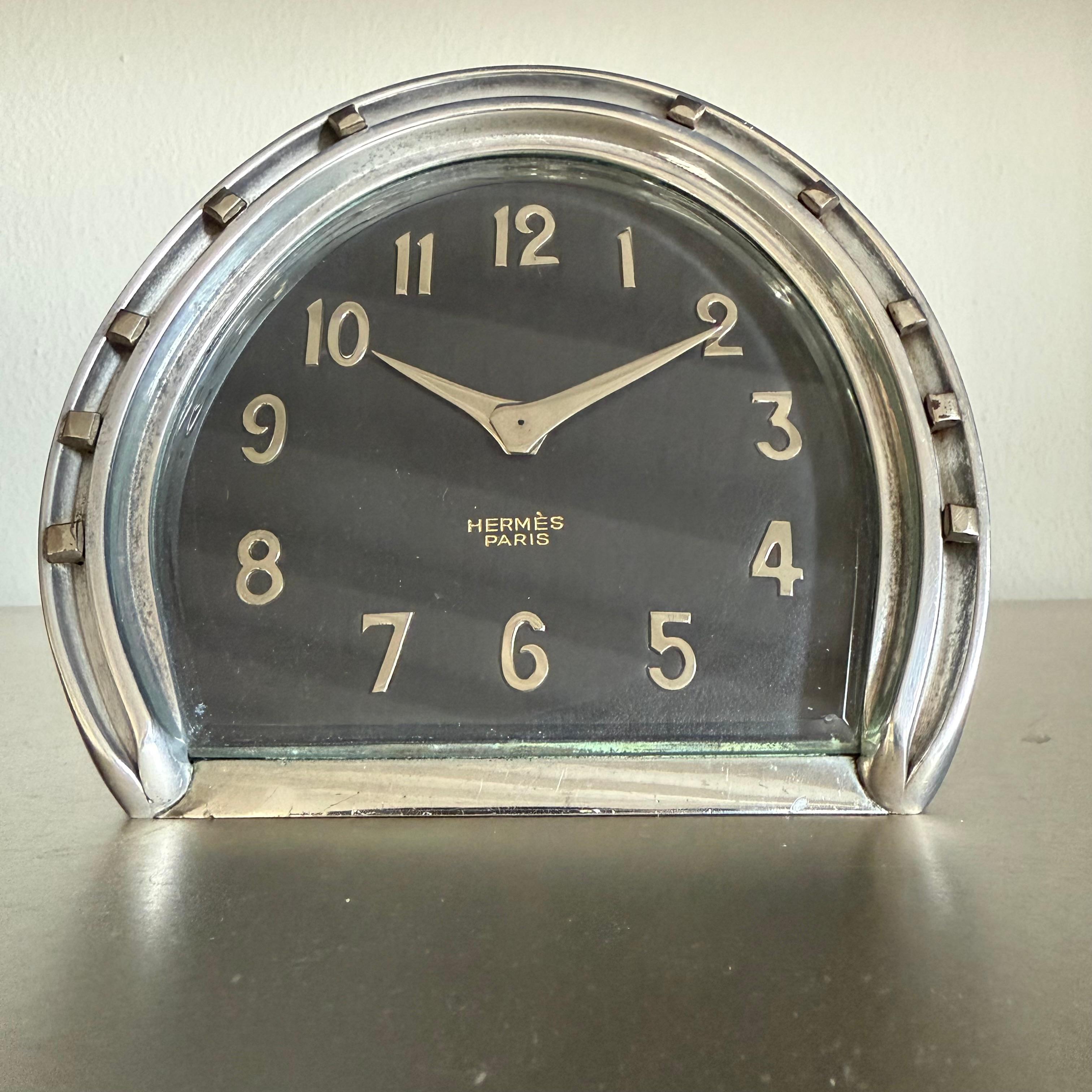 Stunning and extremely rare Hermès desk clock
Made in chrome plated stainless steel
Equestrian design, horseshoe
Black leather dial with  Hermès Paris frontal print
Silver colrerd arabic numbers
The clock has been preserved during the years and runs