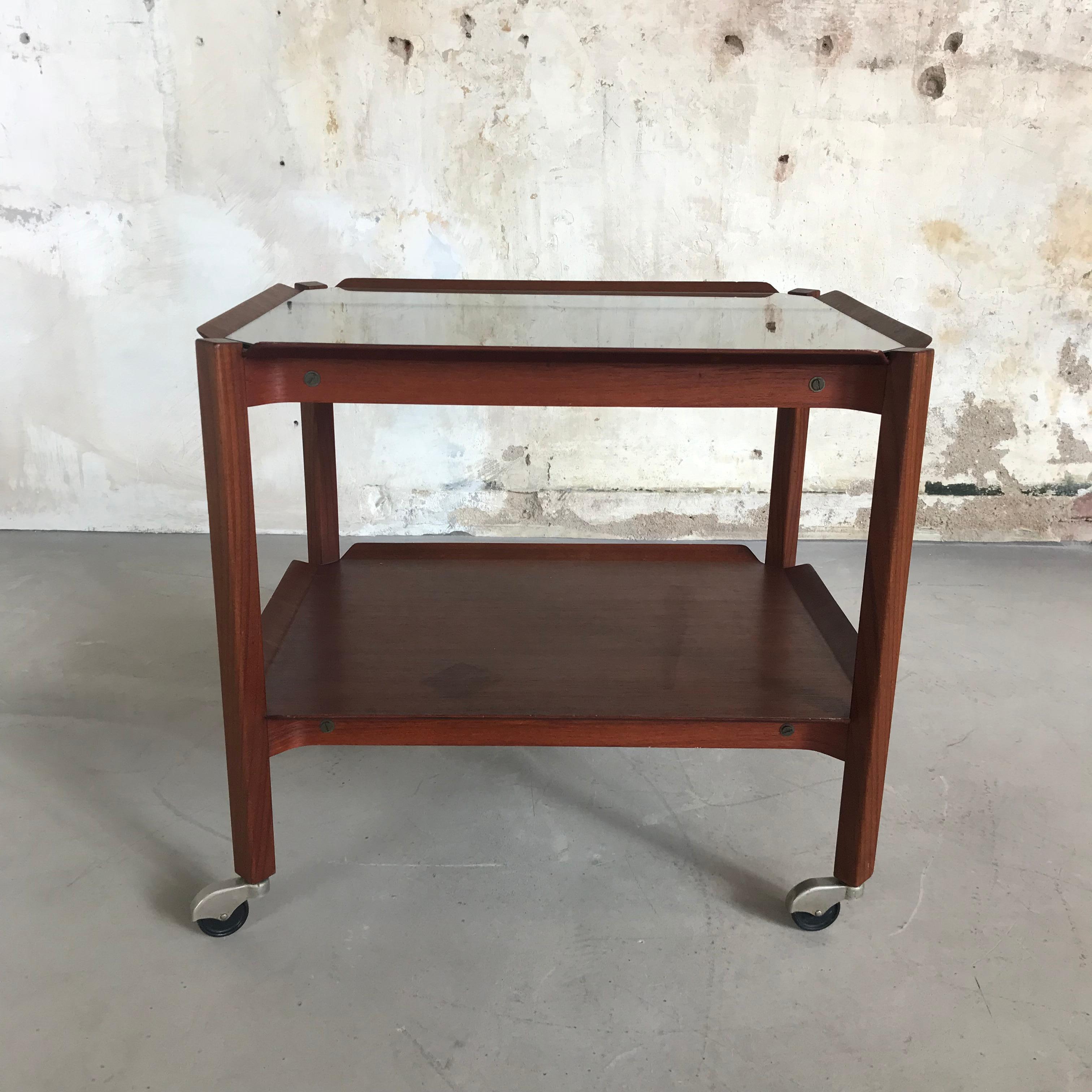 Hard to find midcentury trolley in totally original state. Designed by Cees Braakman in 1959 and produced by UMS Pastoe. The trolley has a solid teak frame and two plates with beautiful folded edges. Comes with original glass top, which is