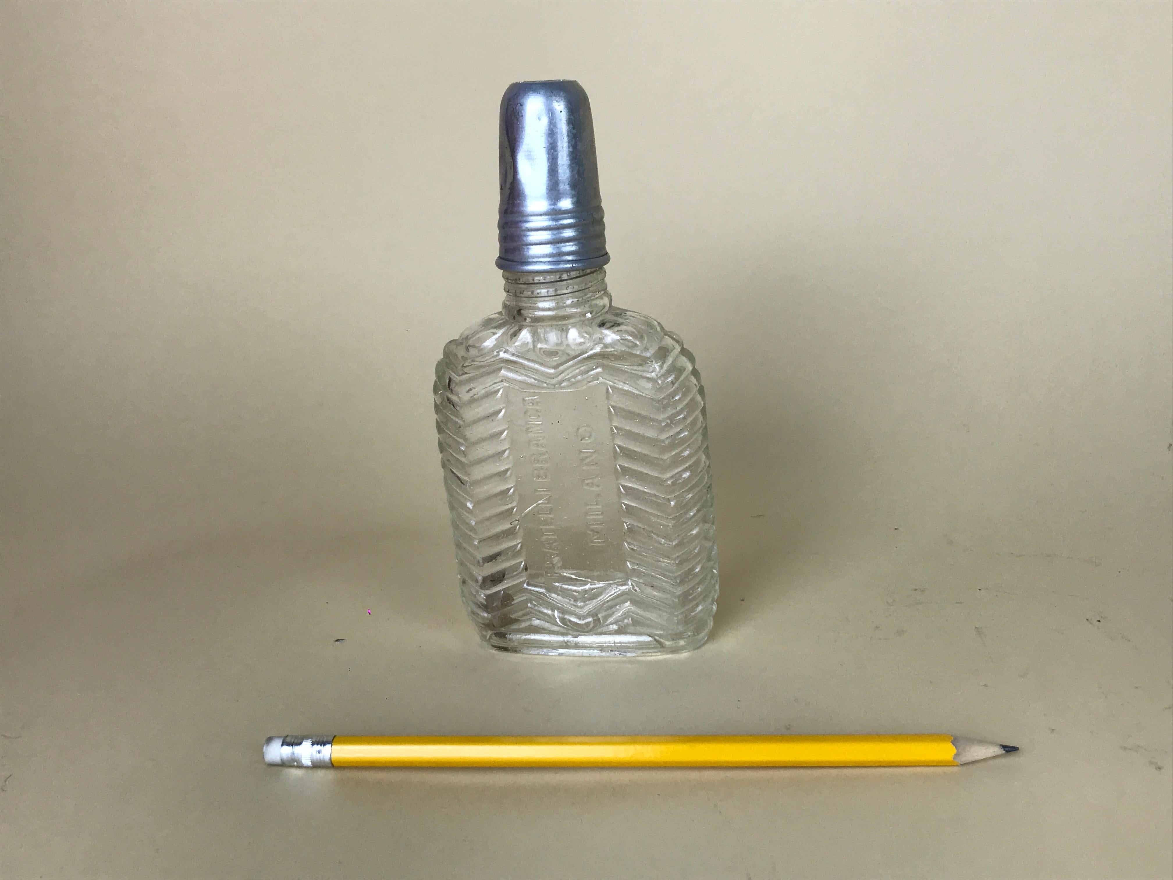 This vintage Fratelli Branca Milano glass flask with a separate small aluminium cup is totally iconic!

Flask is made in glass with a herringbone pattern in relief and marked 
