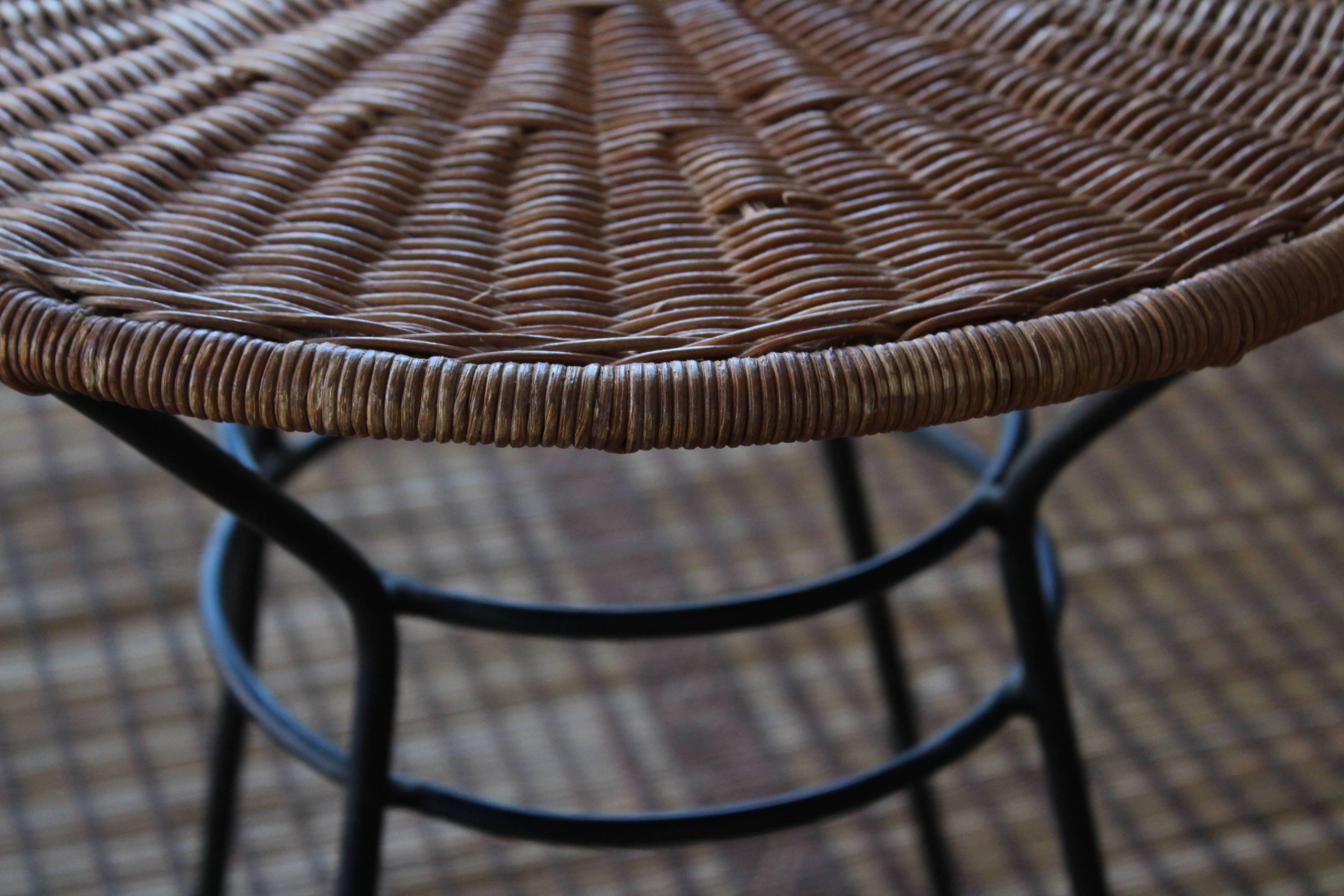 Pair of 1950s side tables with woven rattan/wicker tops and iron bases.