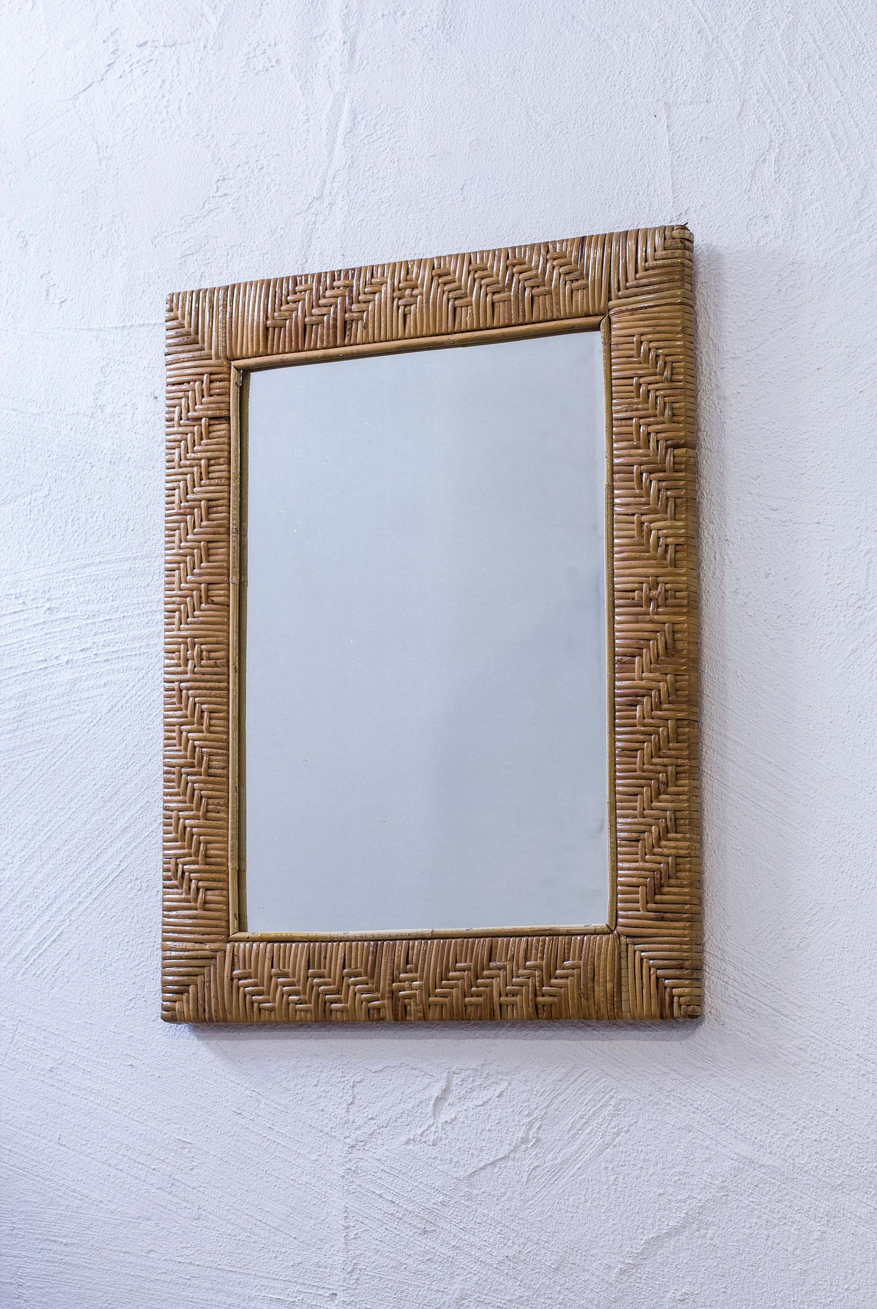 Mirror produced in Finland during the 1950s. Made from solid mahogany with rattan handwoven around the frame. Back part of mahogany as well. Excellent condition with few signs of patina and wear.
 