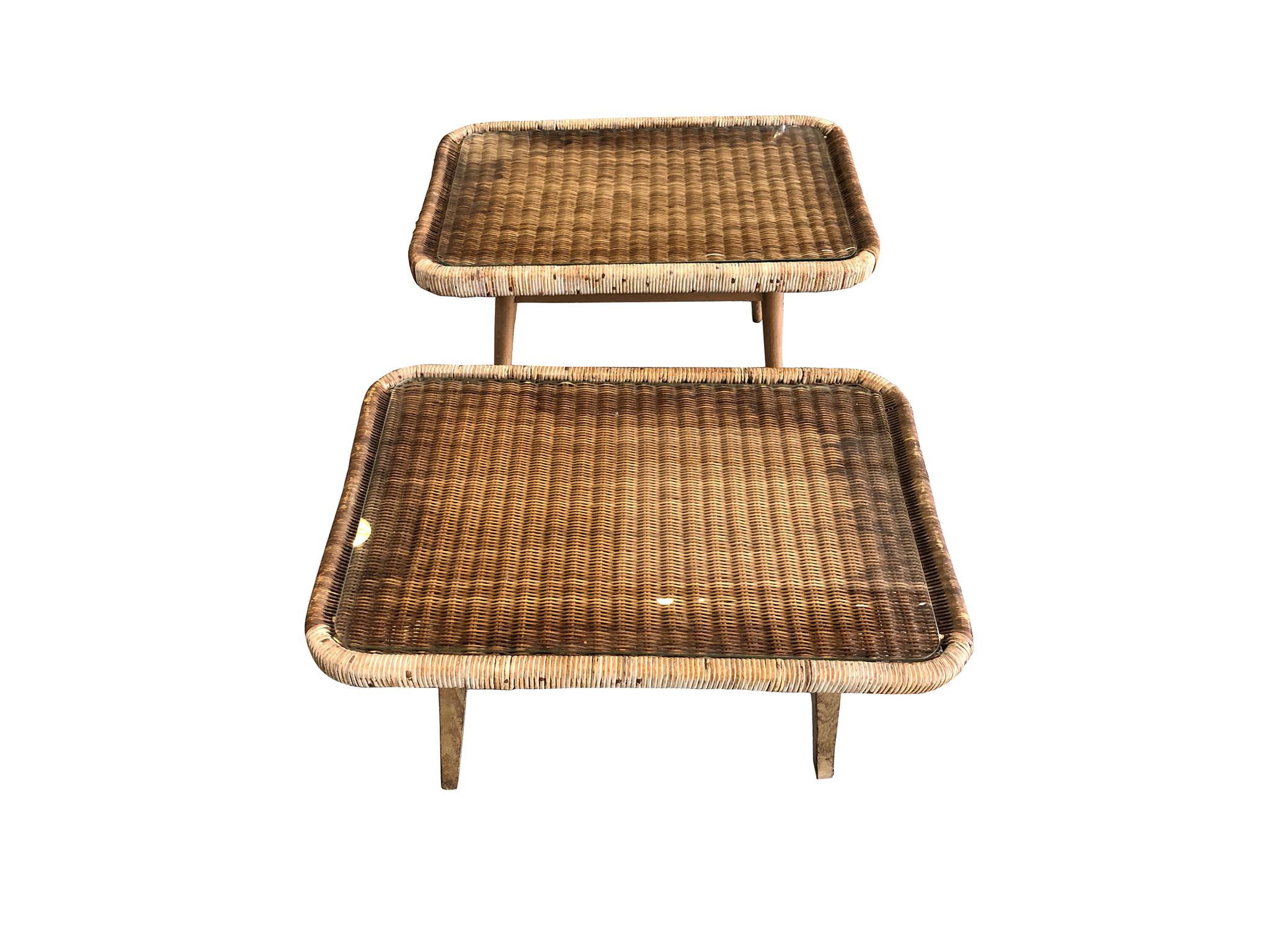 Two midcentury low end-tables handcrafted from rattan and beech, and with a glass insert. This near-pair is attributed to the Japanese modernist designer Isamu Kenmochi. The tables were made by Yamakawa in Tokyo in the 1950s. We love these tables