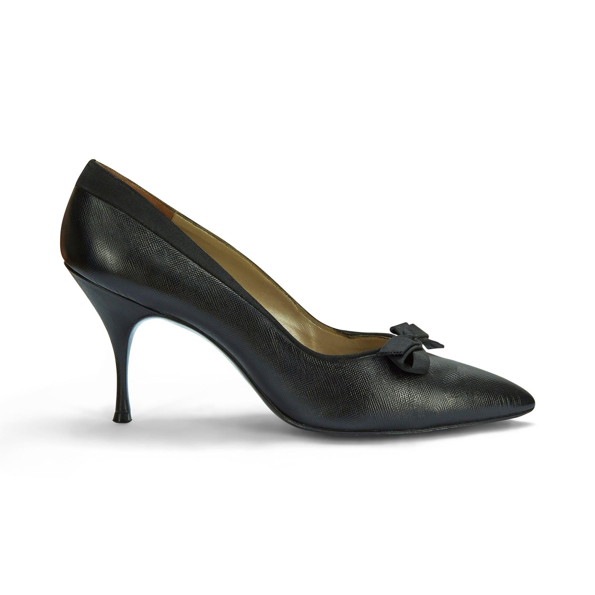 These superb late 1950s to early 1960s Rayne stiletto heeled shoes are embossed internally with the royal warrant alongside the brand name in gold lettering. Crafted from textured Saffiano leather, they are trimmed with black grosgrain and finished