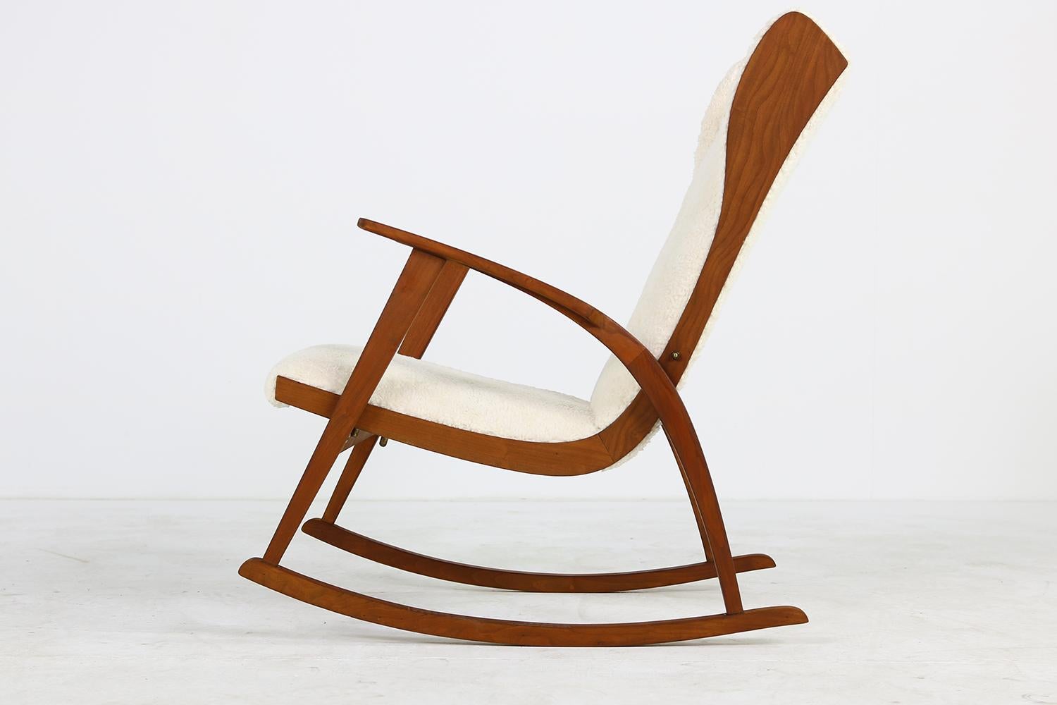 Beautiful 1950s rocking chair, Mid-Century Modern, made in Germany. Cherrywood, stained in teak, cotton eco teddy fur, tufted with leather buttons. Beautiful condition, made like this one, for sure an unique item. The main part can be arranged in