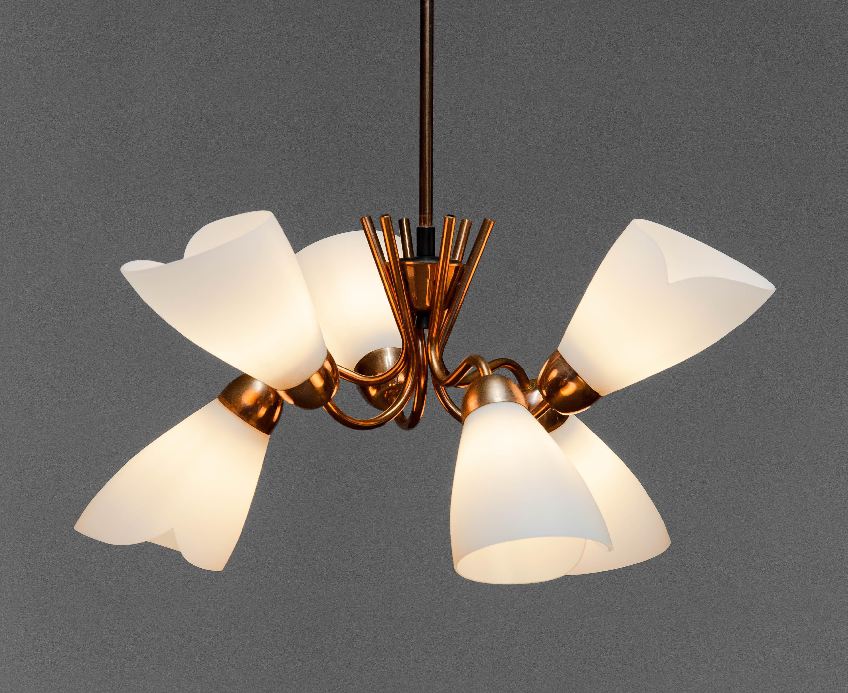 Un lampadario di design svedese assolutamente bellissimo, realizzato negli anni '50.
L'apparecchio è realizzato in rame rosso con sei bracci in rame rosso che reggono ciascuno il proprio paralume originale in vetro opalino.
Questo lampadario è in
