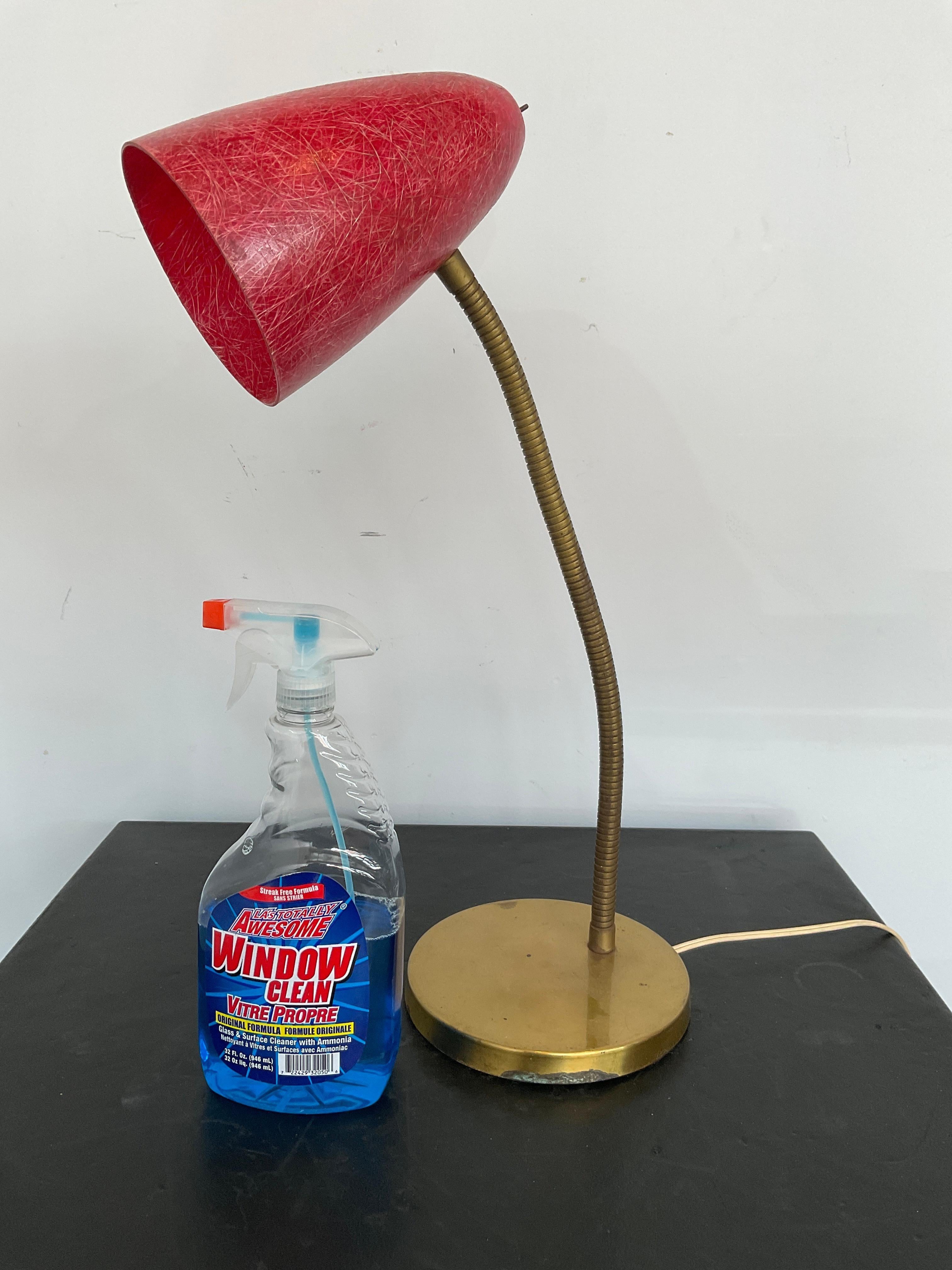 Fiberglass shade on brass coated base with adjustable arm lamp.