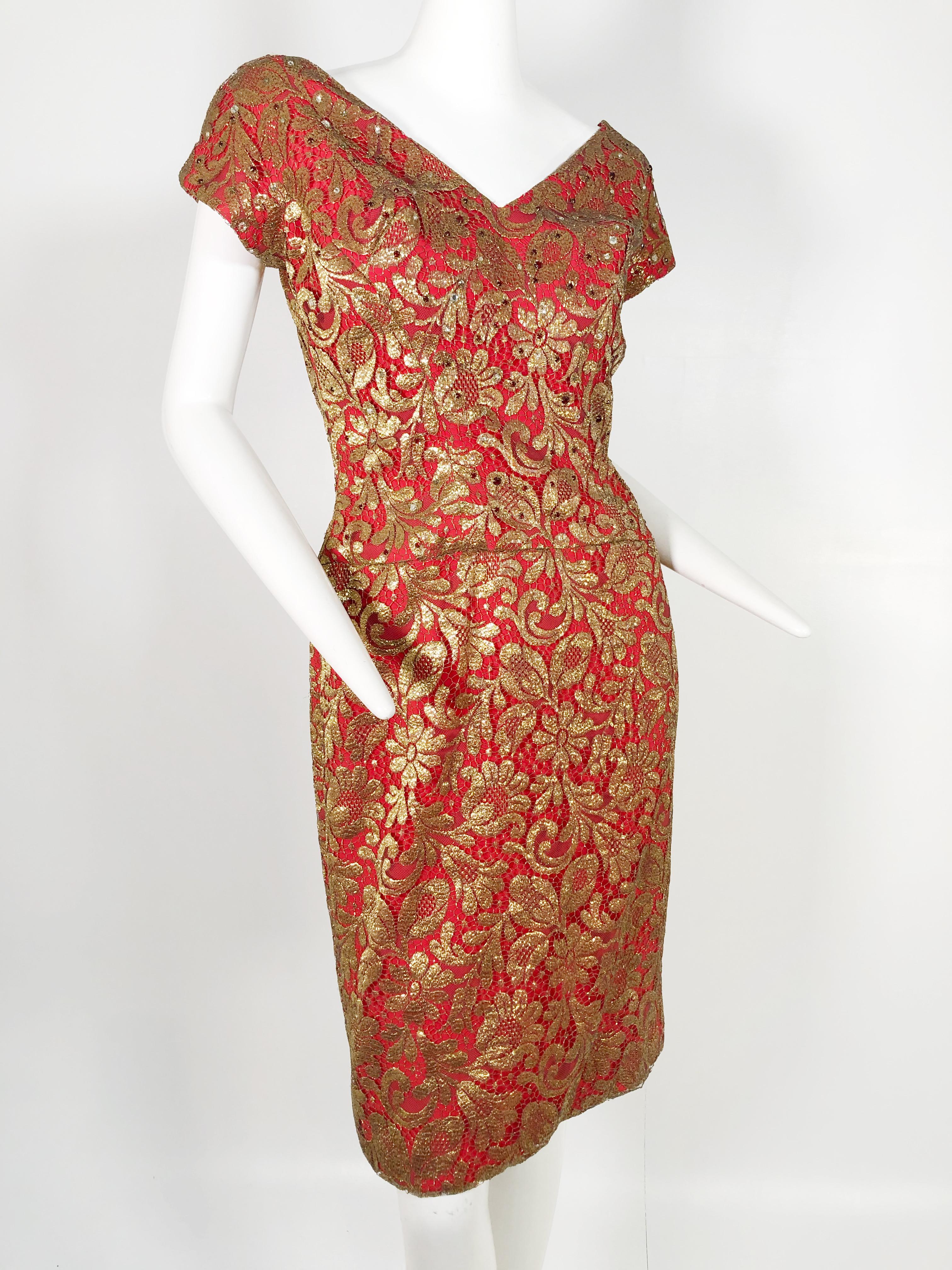 A beautiful 1950s-early 1960s deep red sheath dress with plunging décolletage, gold lame leaf-patterned overlay and scattered garnet-tone stones across the bodice.  Cap sleeves and back zippers. Gathered shoulders with full volume and mini shoulder