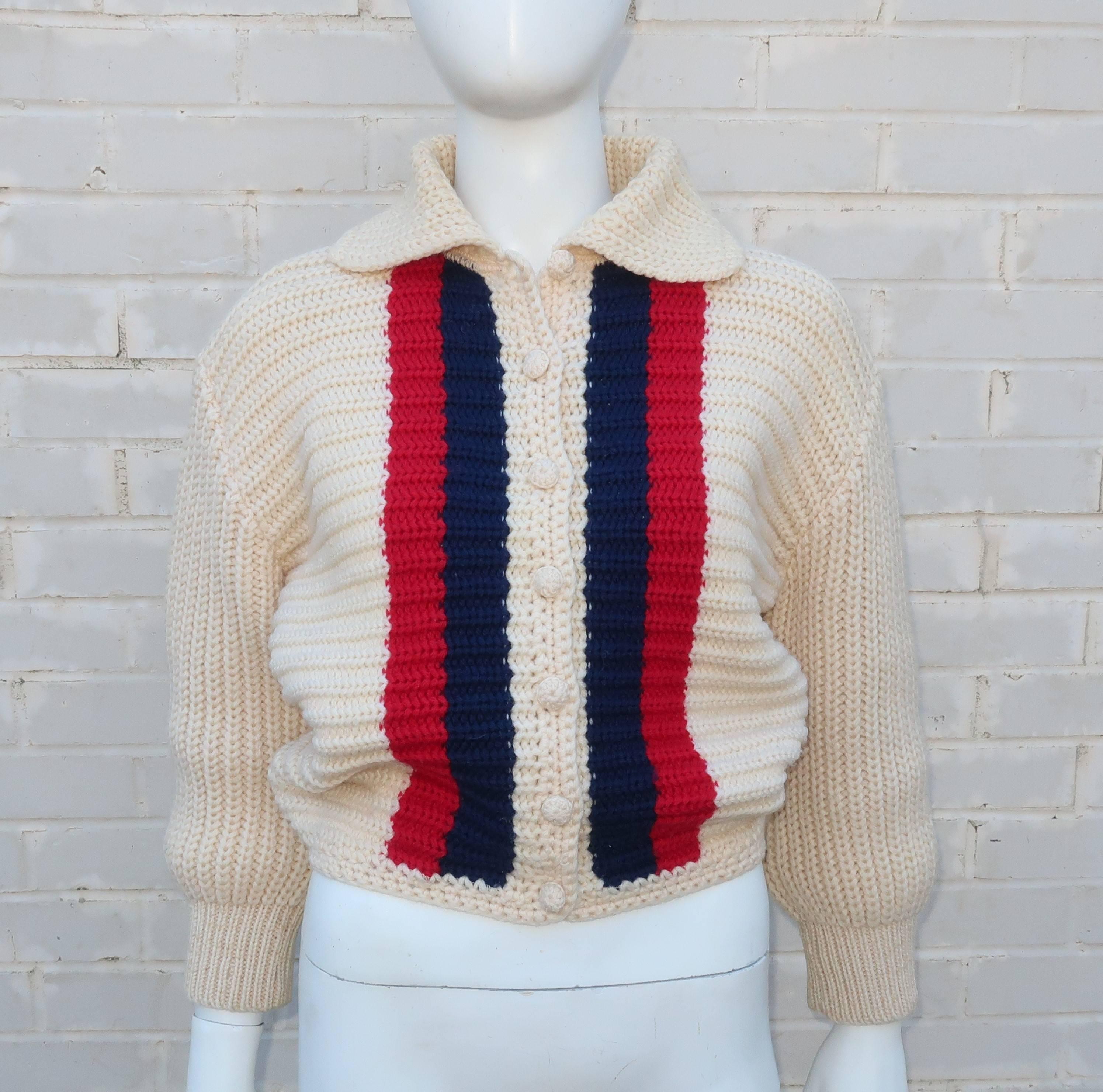 This adorable 1950’s sporty cardigan sweater is aptly named ‘Bulkies’ by LeRoy Knitwear.  The wool sweater is hand knit with a cropped batwing style silhouette in an off-white with a sporty blue and red stripe.  The sweater buttons up the front with
