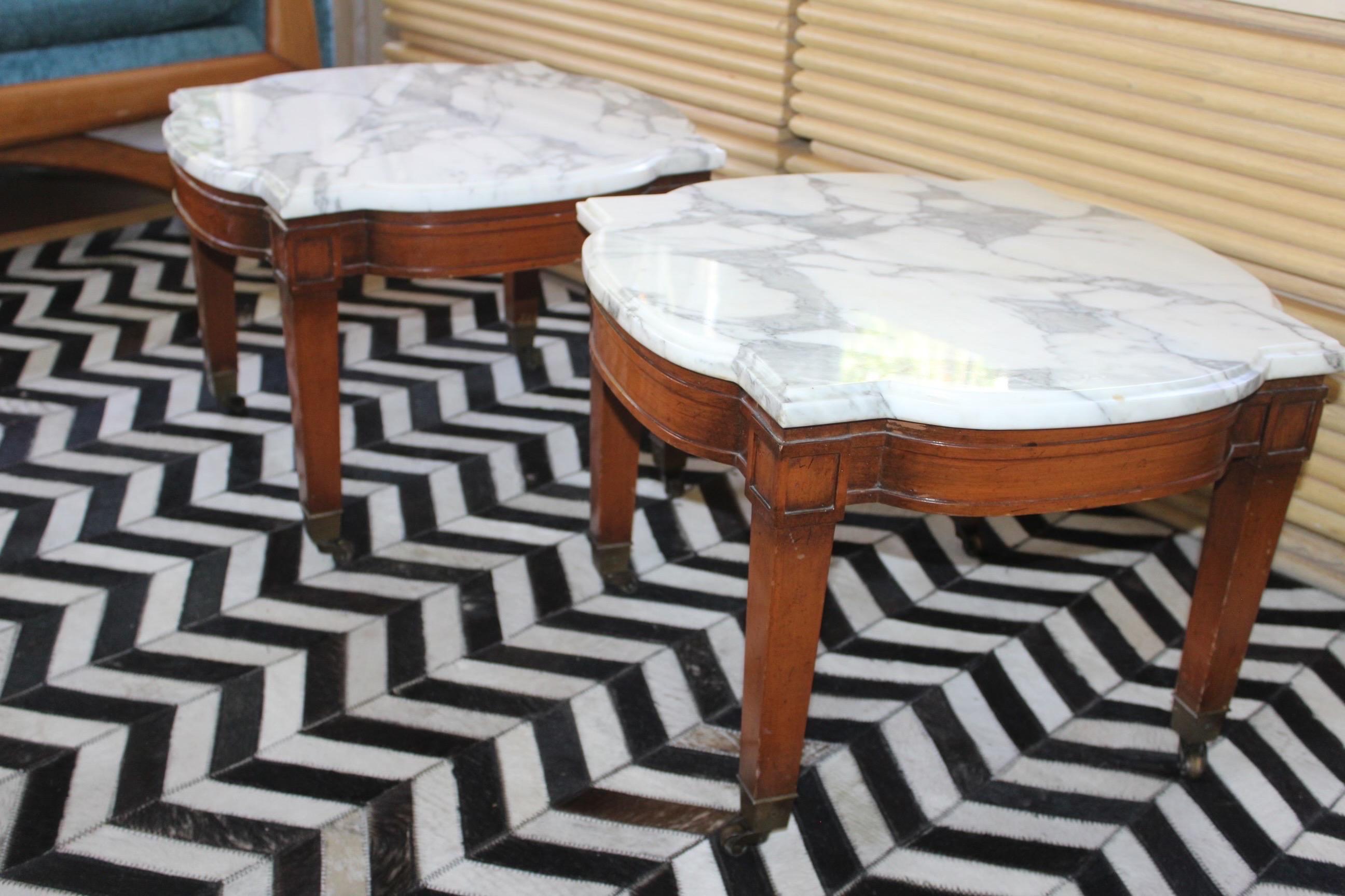 Pair of elegant 1950’s Regency Mahogany Side Tables on brass casters. Obtains original oragami shaped Carerra Italian marble . Marble top removable for easy transport.