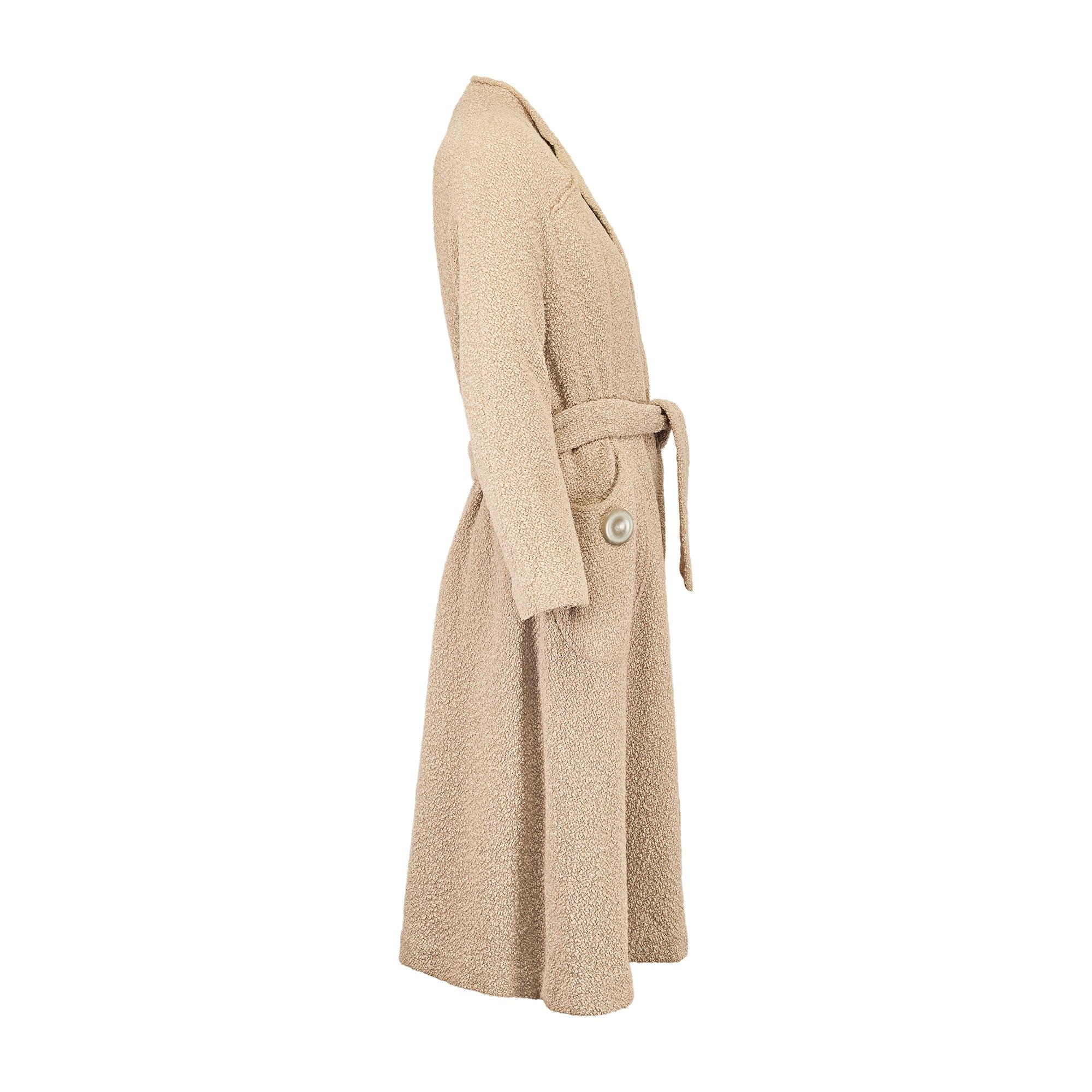 Questo elegante cappotto è stato disegnato dal marchio londinese di prêt-à-porter Rensor nei primi anni Cinquanta. È realizzato su misura in lana bouclé in una tonalità crema color latte. È tagliato secondo la classica forma swing, popolare durante