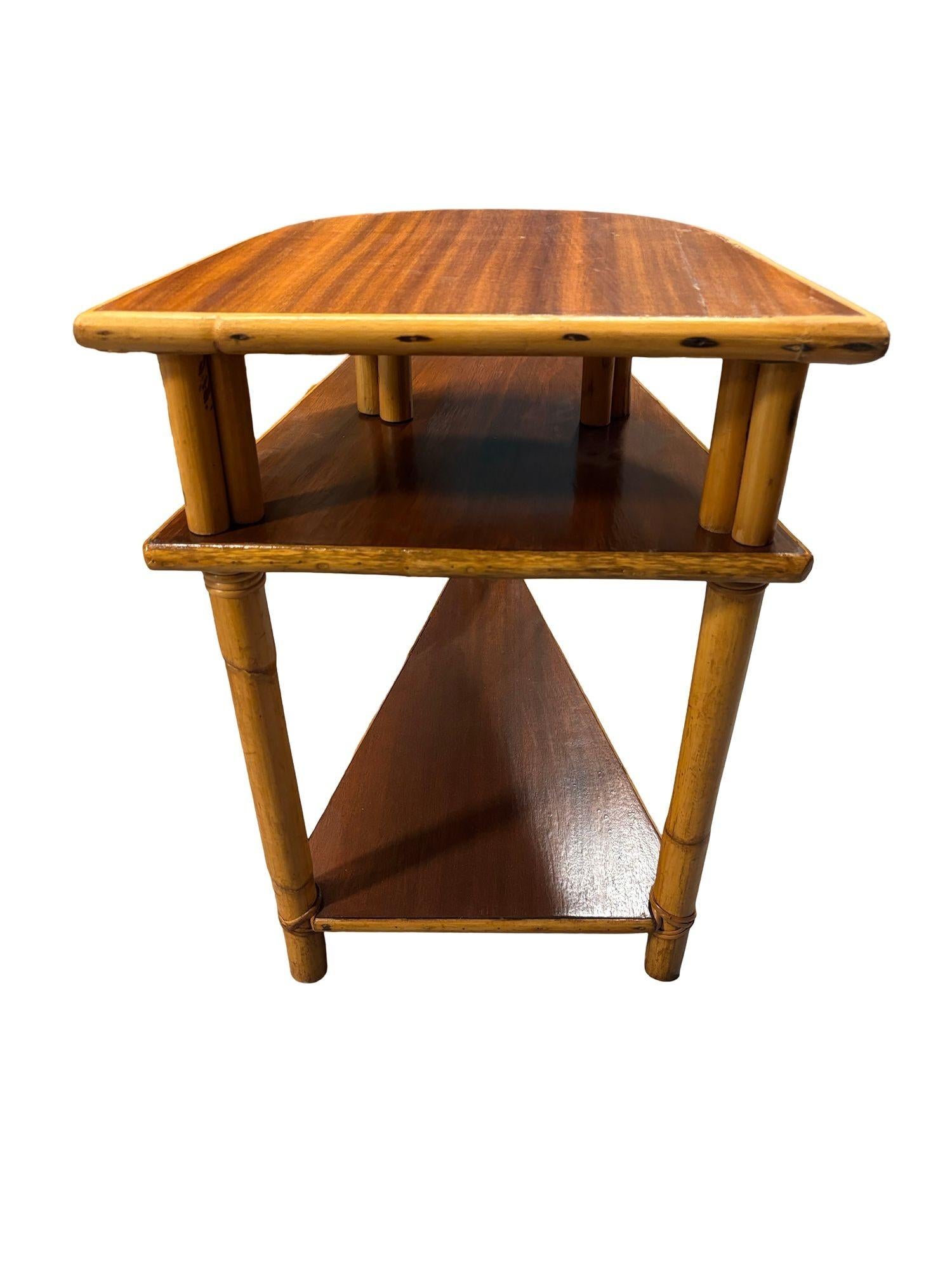 This unique piece features beautiful mahogany tops paired with classic rattan siding. Designed with Paul Frankl's signature style, it features pole rattan legs, the table has a distinctive two-tier, triangular wedge shape. Originally created to fit