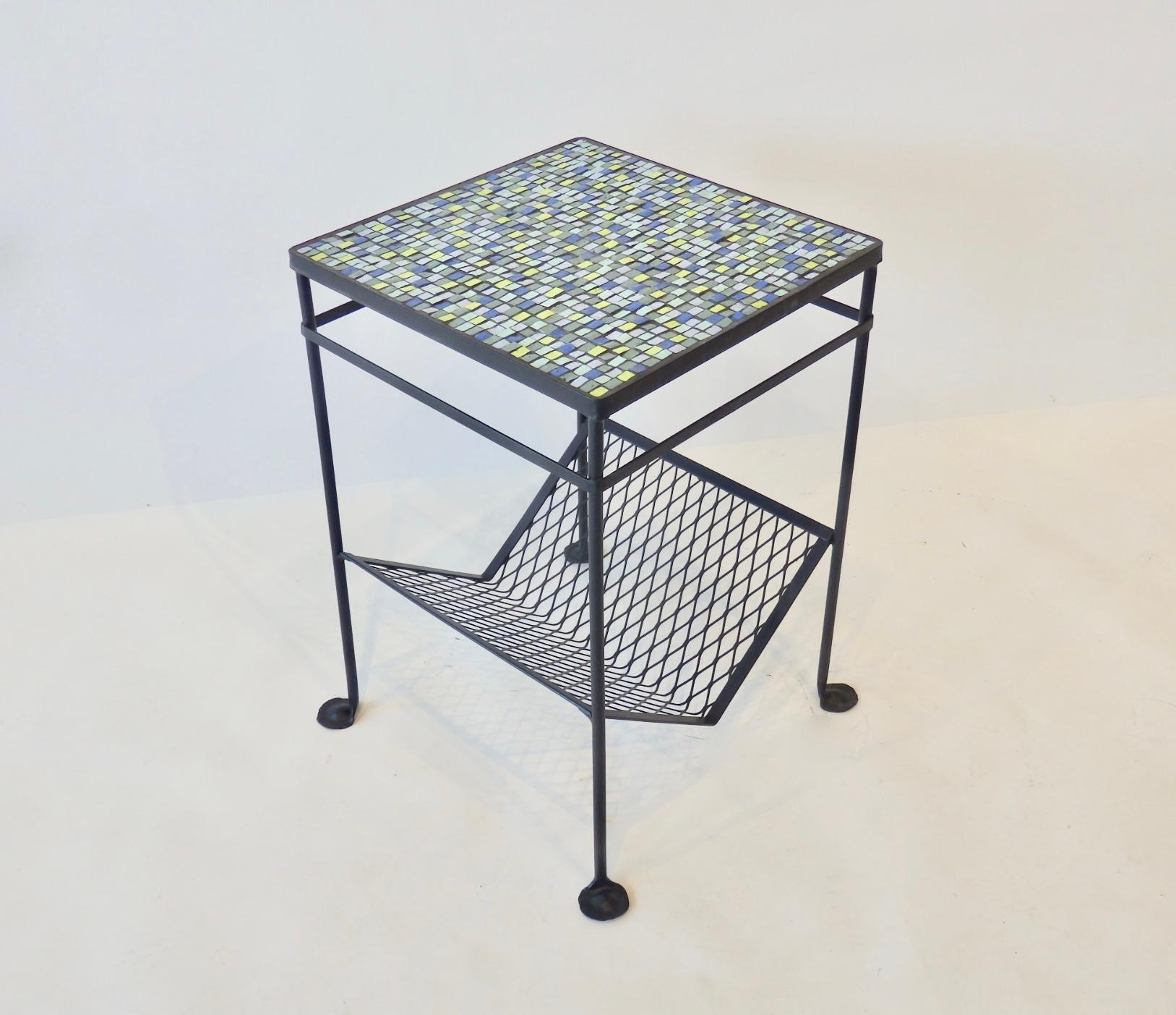 A one of a kind handcrafted mosaic top table made with thick Italian tile on a restored vintage wrought iron frame with magazine rack.   
Suitable for indoor or outdoor use.
The footed legs able you to secure the table in the garden as a option.
