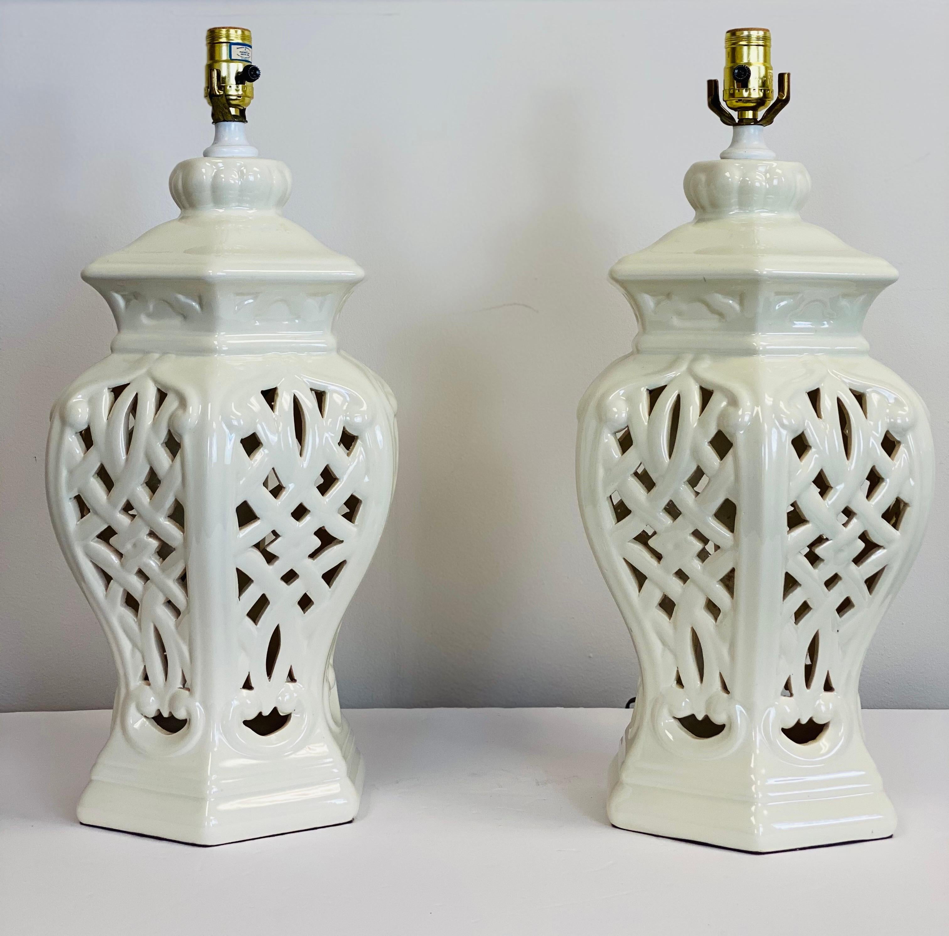 We are very pleased to offer a beautiful pair of reticulated white glazed porcelain lamps, circa the 1950s. These lamps were made by Light House Lamp & Shade Co, a Los Angeles based manufacturer and designer of lamps. The shades unique curvilinear