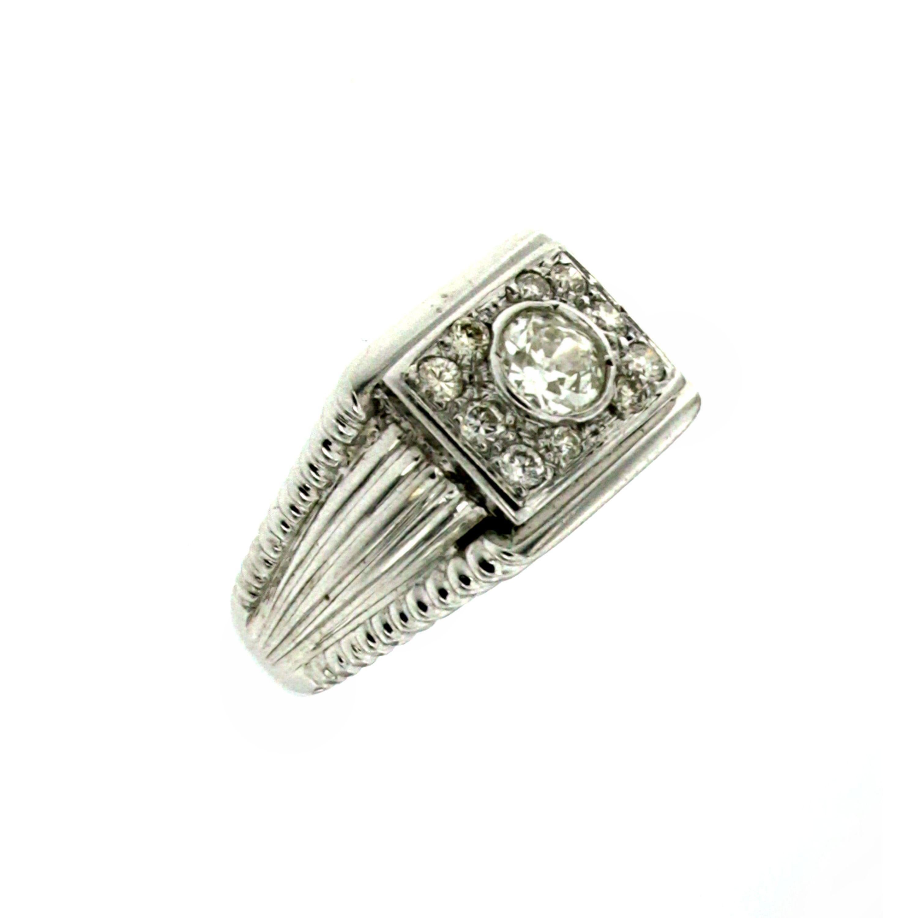 A Beautiful Retro band ring hand made in 18k White Gold and set with 1 large European Cut Diamond in the center, weighs 0,60 ct graded H/I color Vs clarity, surrounded by 0,50 carat of diamonds pave setting graded G/H color.
The setting featuring a